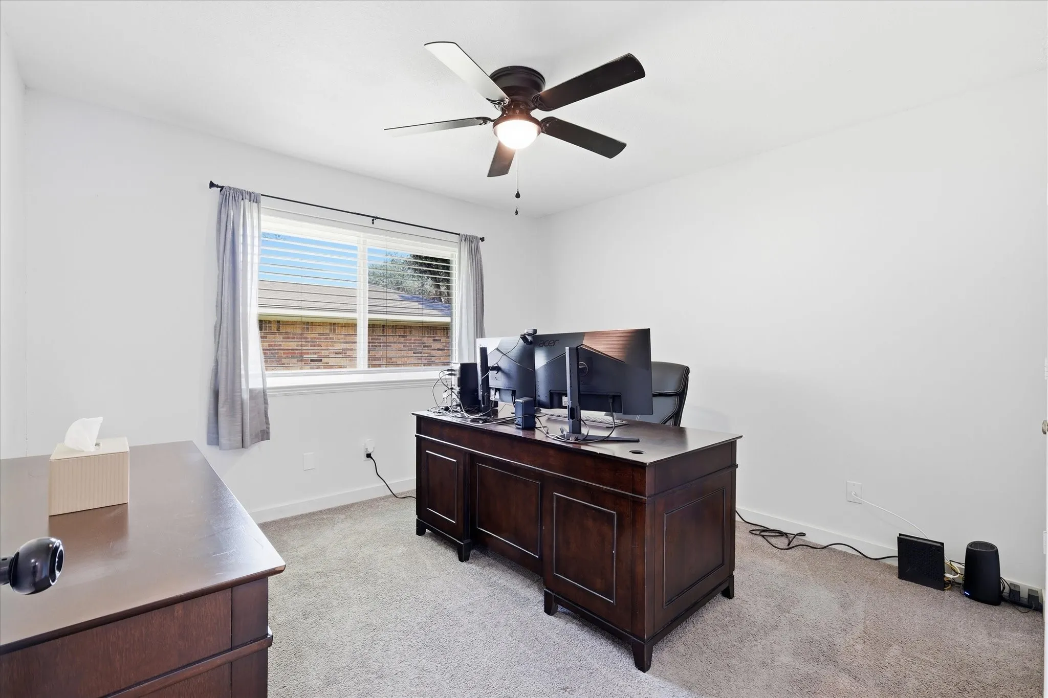 Carpeted room with a ceiling fan, a window with blinds, and white walls