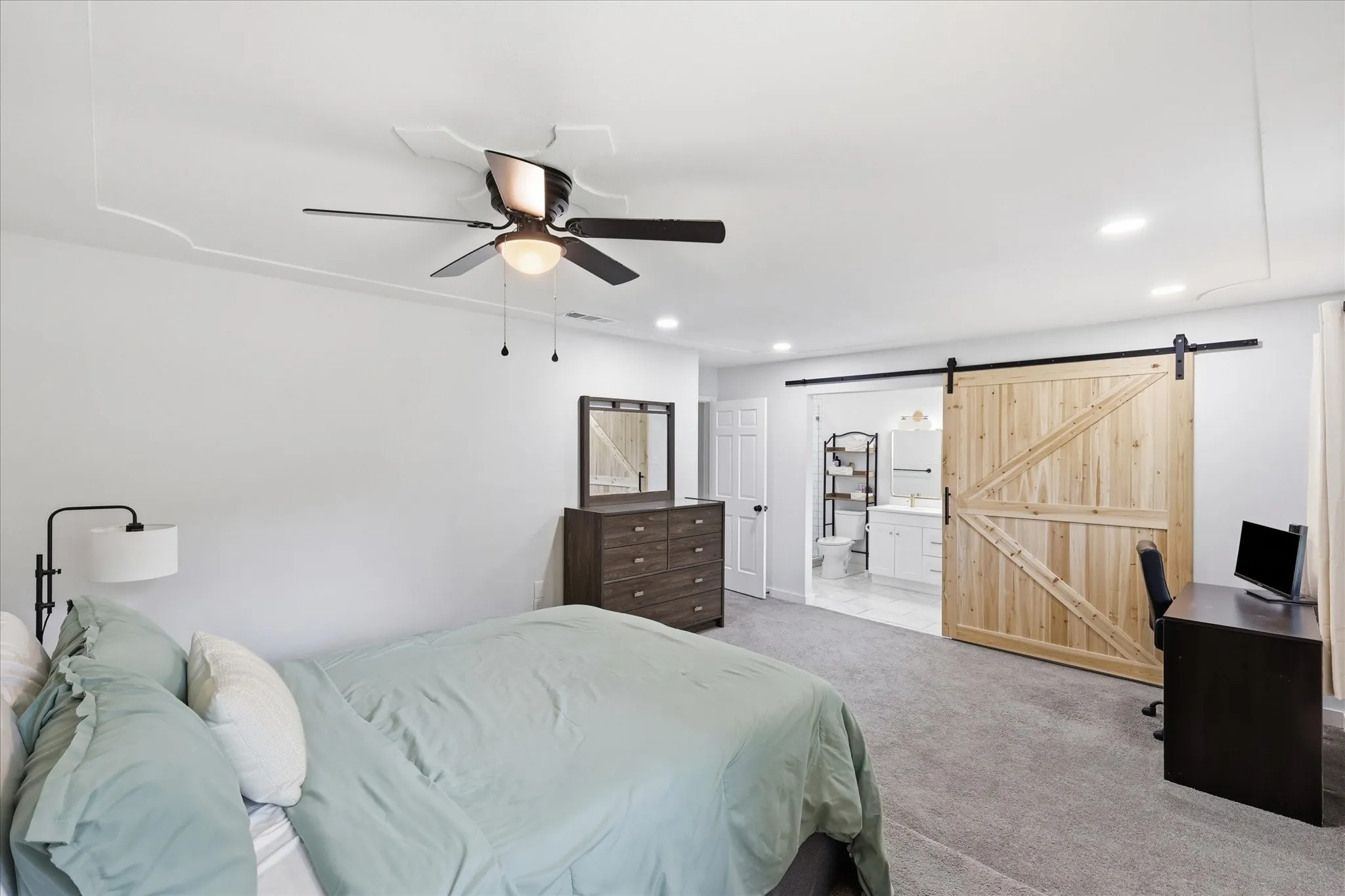 Spacious room featuring light-colored carpeting, recessed lighting, and a ceiling fan