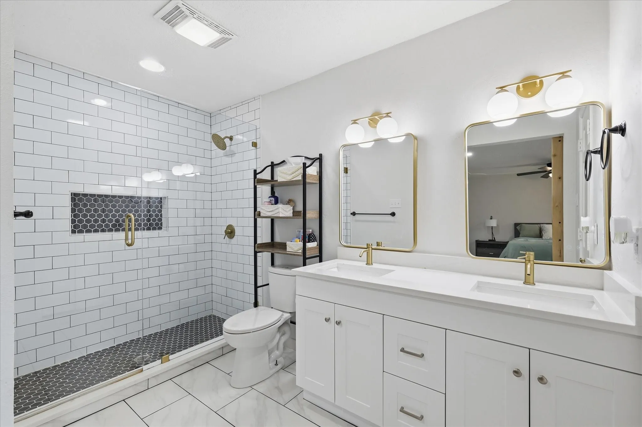 Dual vanity with white cabinetry, gold-finish fixtures, and integrated sinks