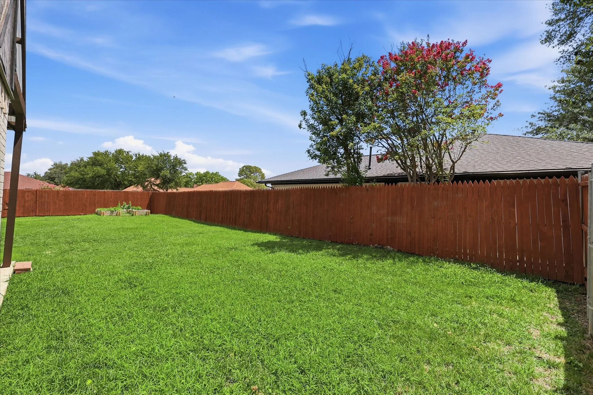 Expansive green lawn with a wood privacy fence
