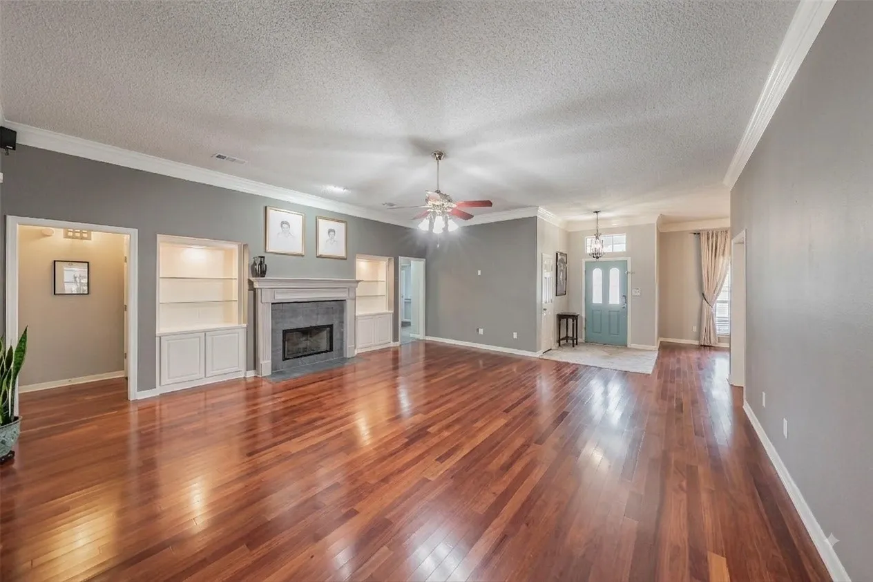 Enhanced with AI.  All of the furniture has been taken out so you can picture what you would do in this huge family room with gas fireplace and built ins.