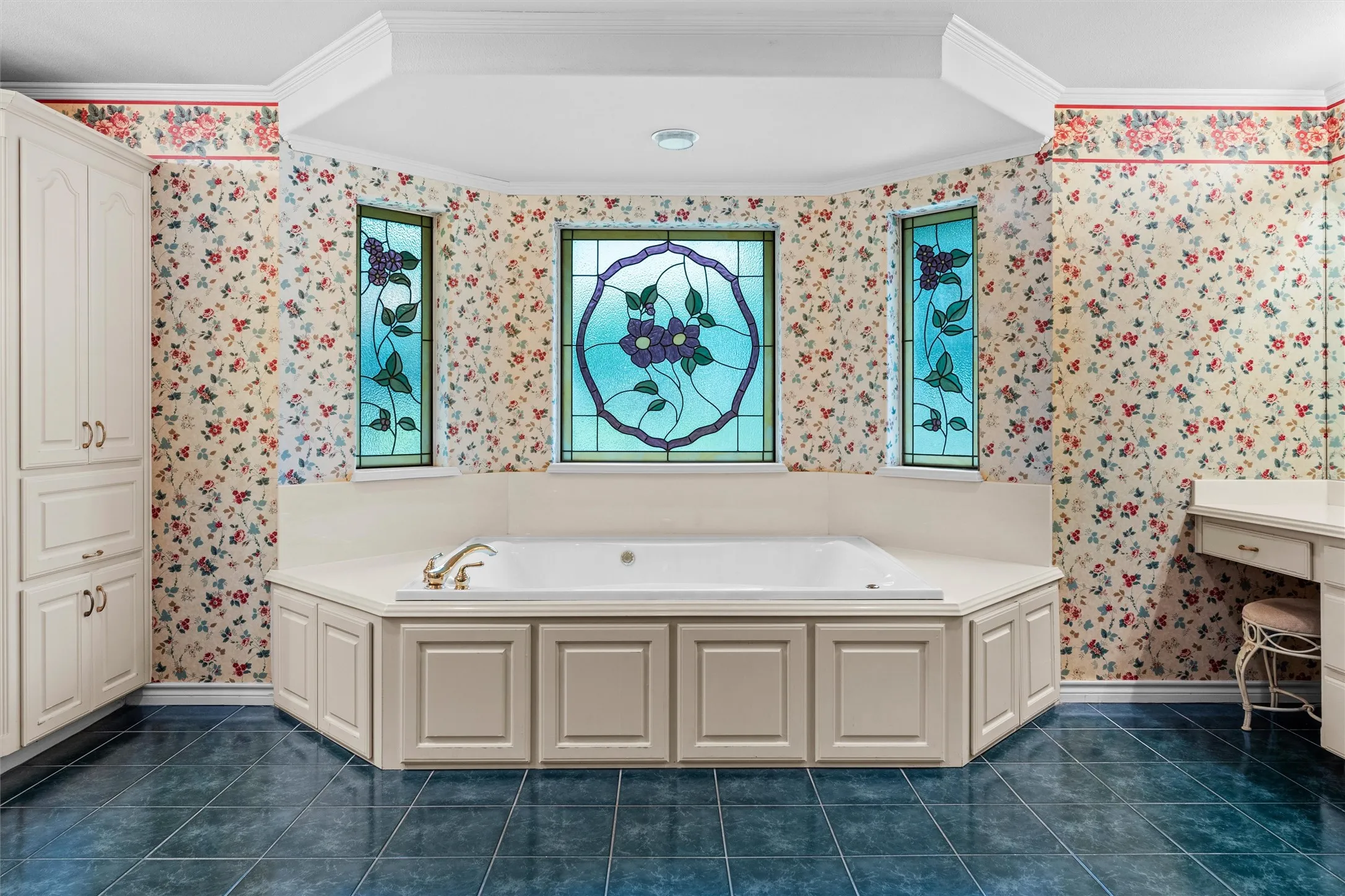 Recessed jetted tub with an integrated deck, surrounded by three stained-glass windows