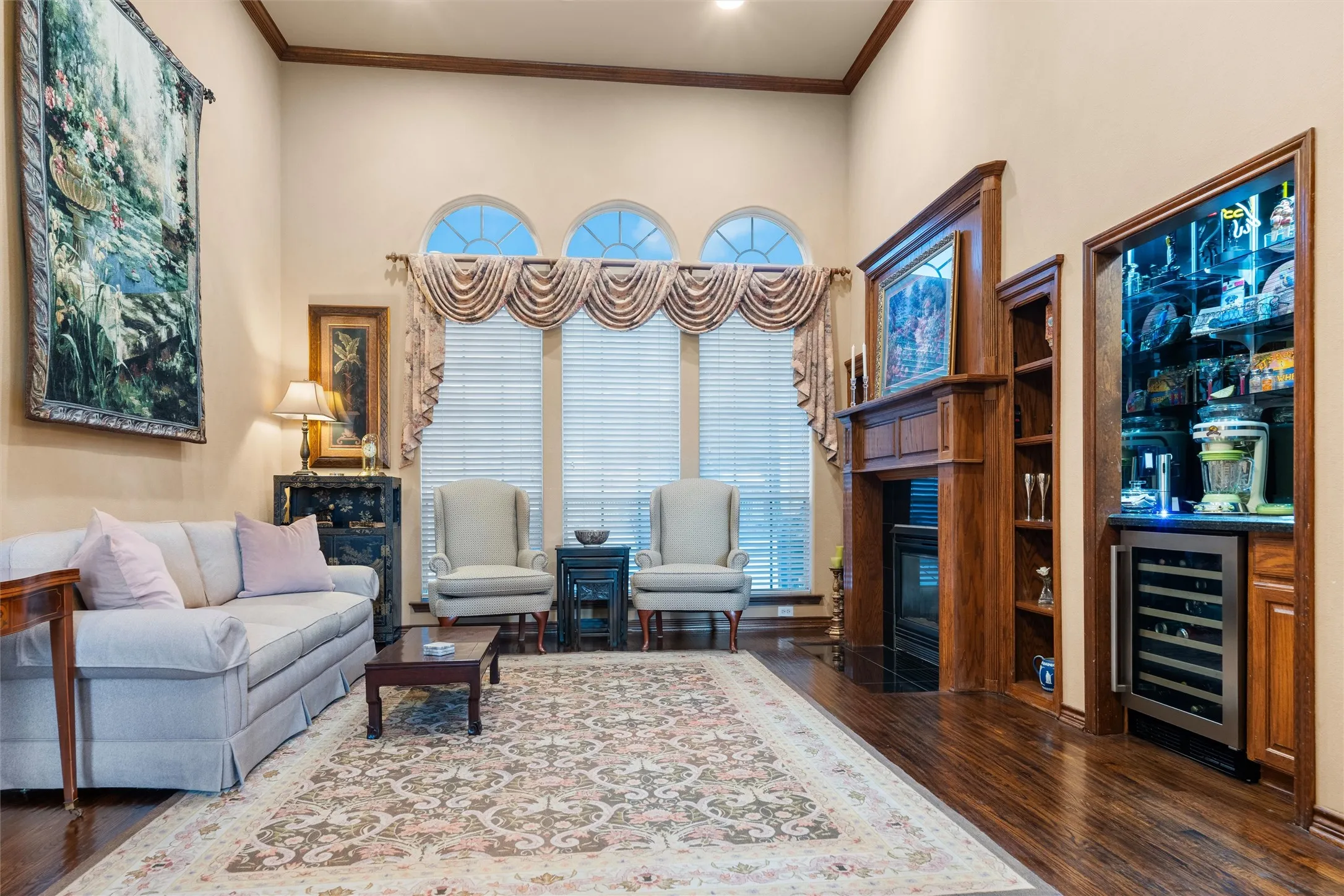 Tall ceilings with crown molding and wood-finish flooring. Could be a piano room or even a private study.