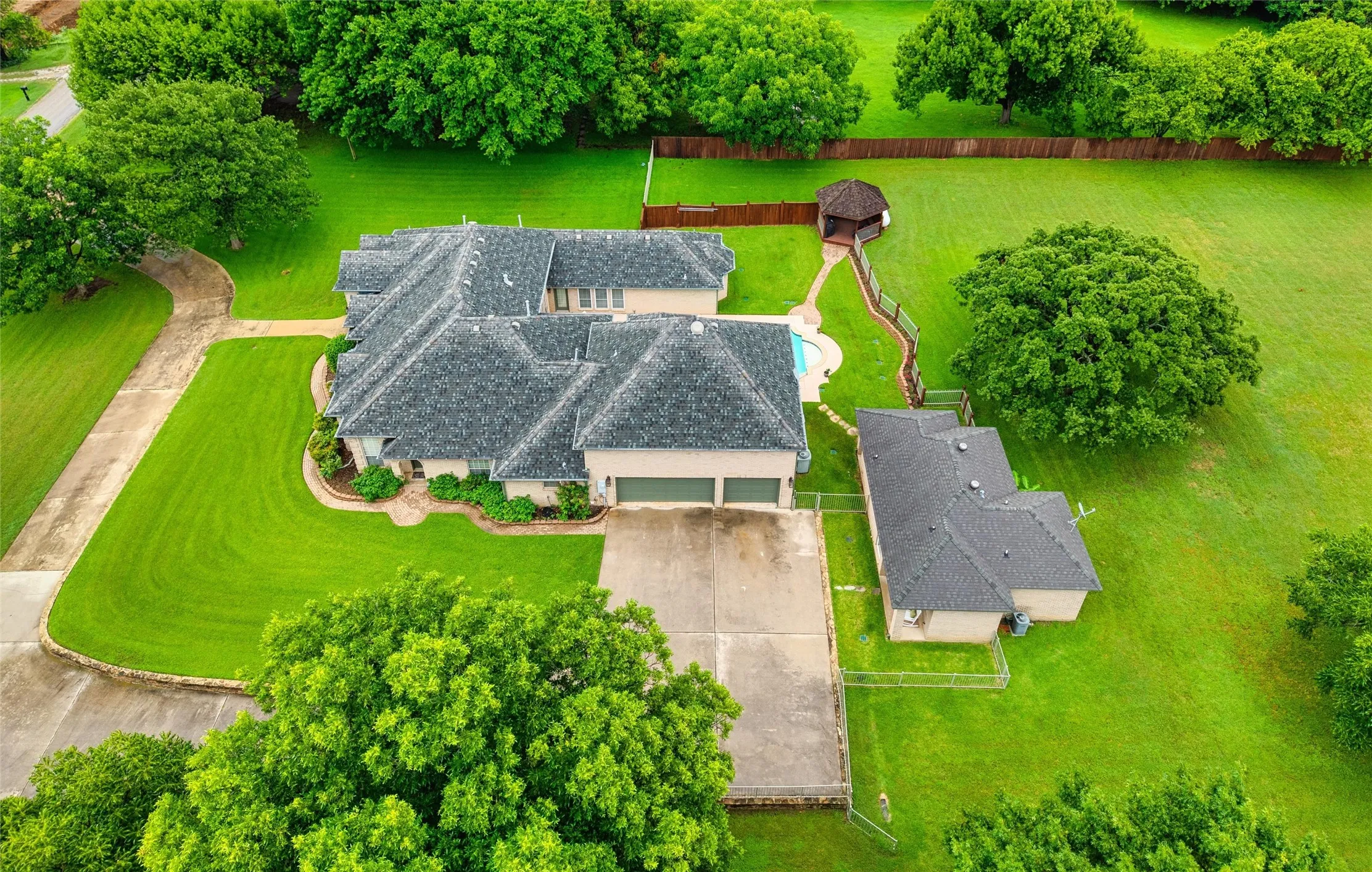 Expansive 1.66 acre property featuring a large residence with an multi car attached garage, a separate guest house