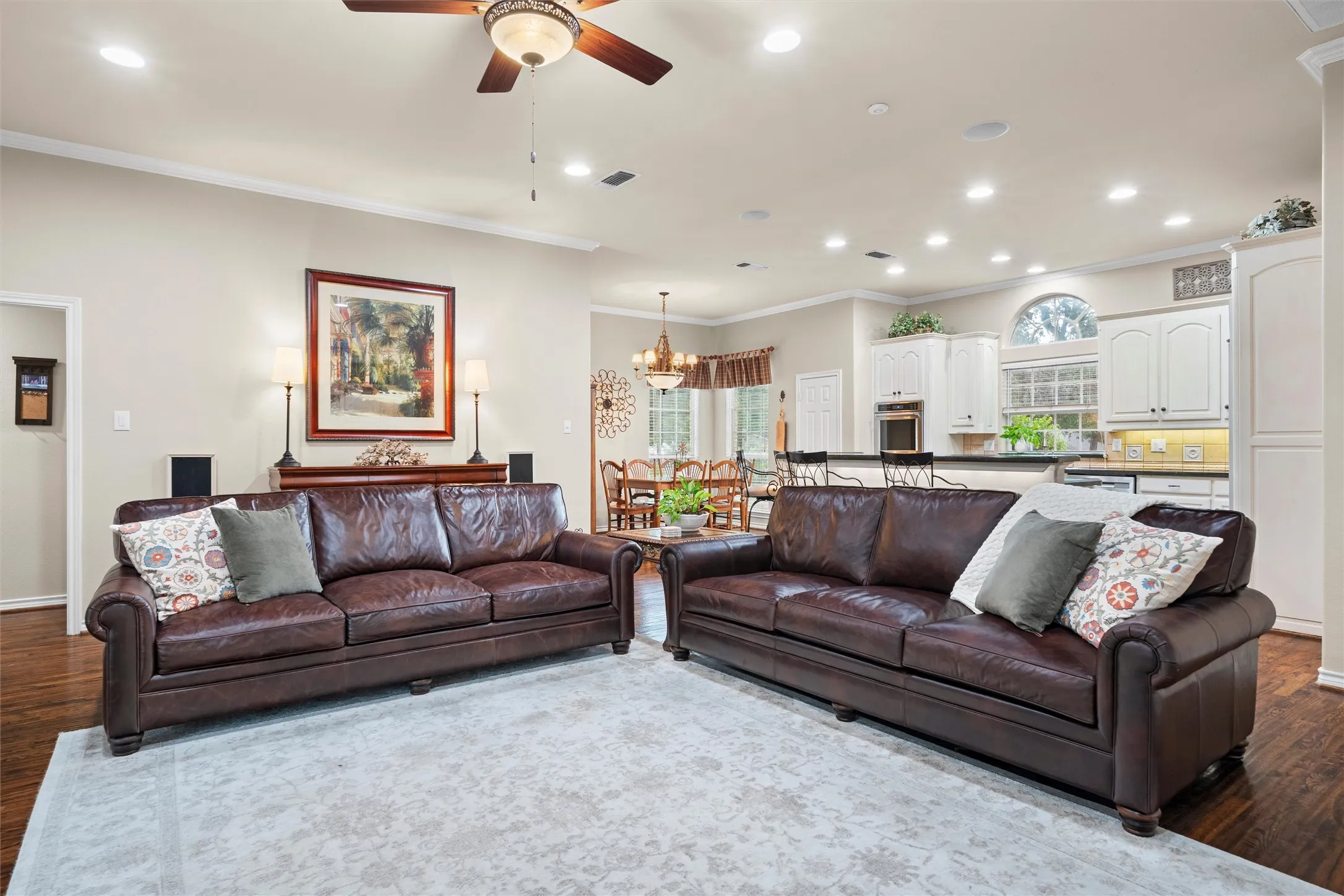 Expansive living area featuring crown molding, recessed lighting, and wood-finish flooring