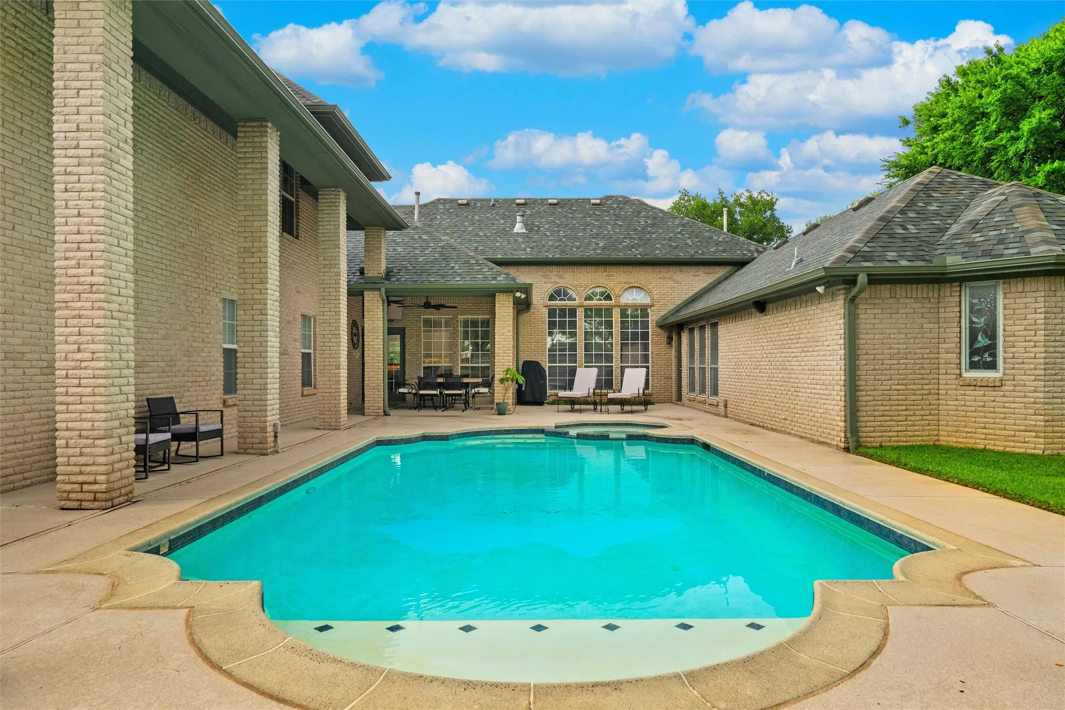 Rectangular swimming pool with integrated spa and concrete decking