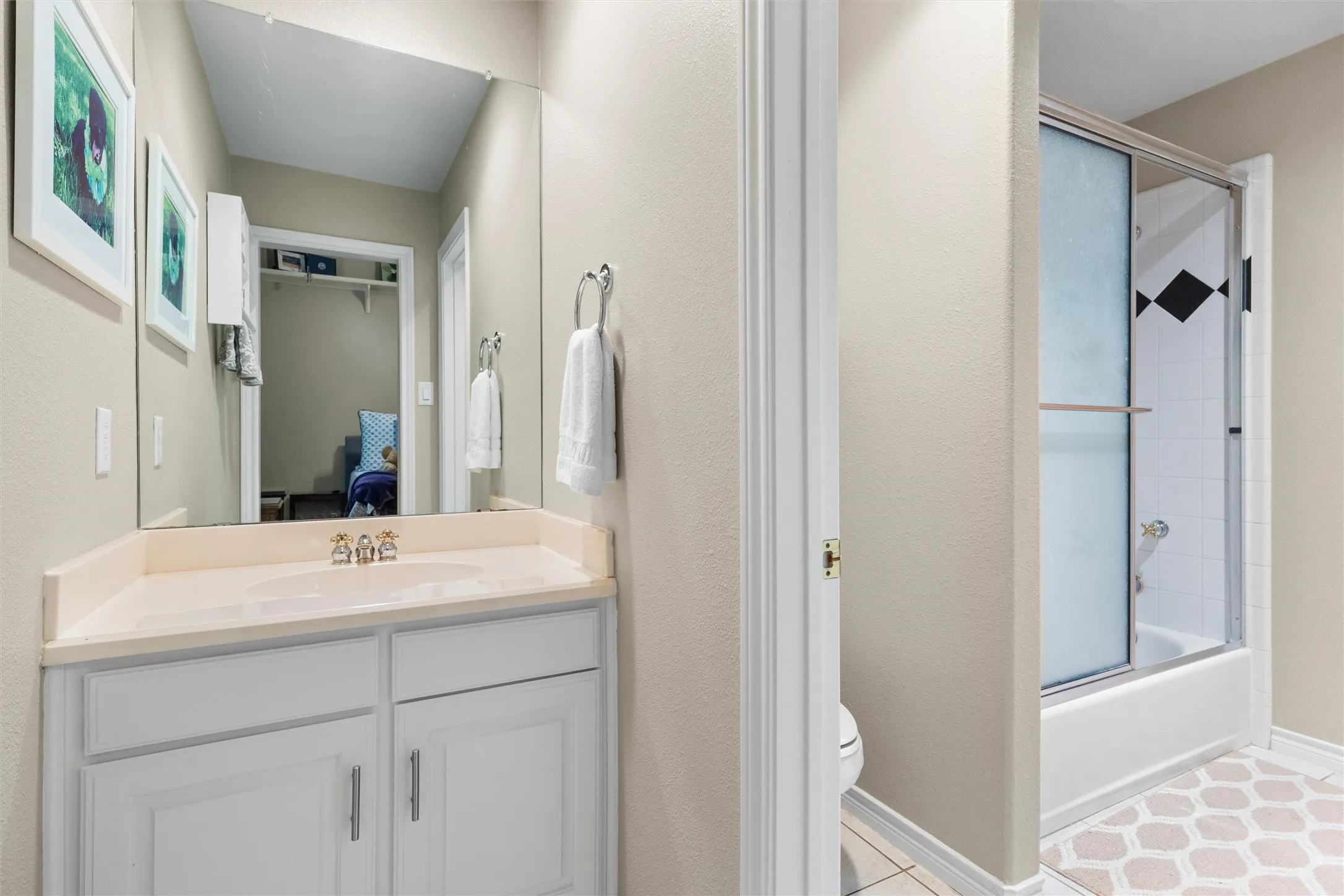 Jack n Jill bathroom featuring separate vanities, and adjacent tub/shower combo.