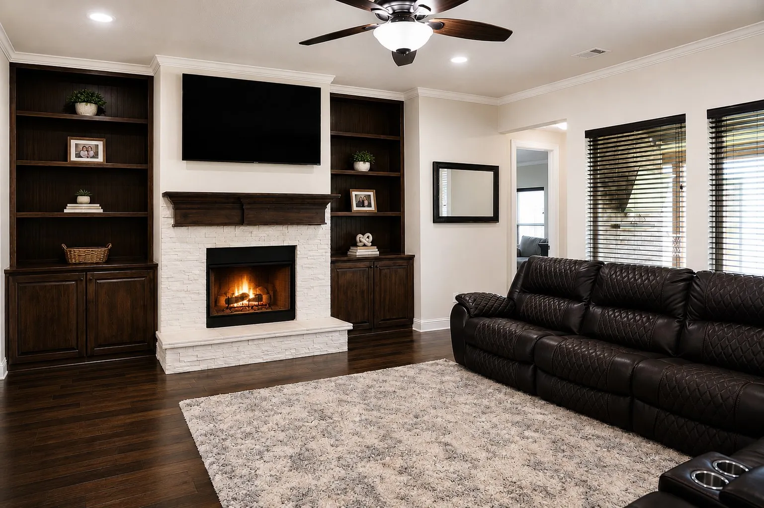 Built-in shelving flanking a stone-clad fireplace with a dark wood mantel