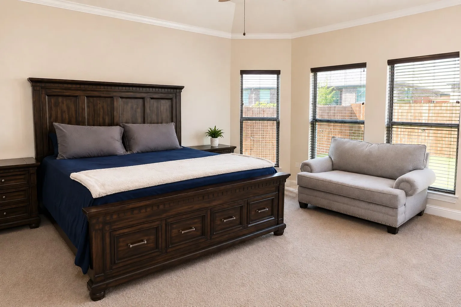 Recessed windows with blinds, neutral wall paint, ceiling fan, carpet flooring, and crown molding