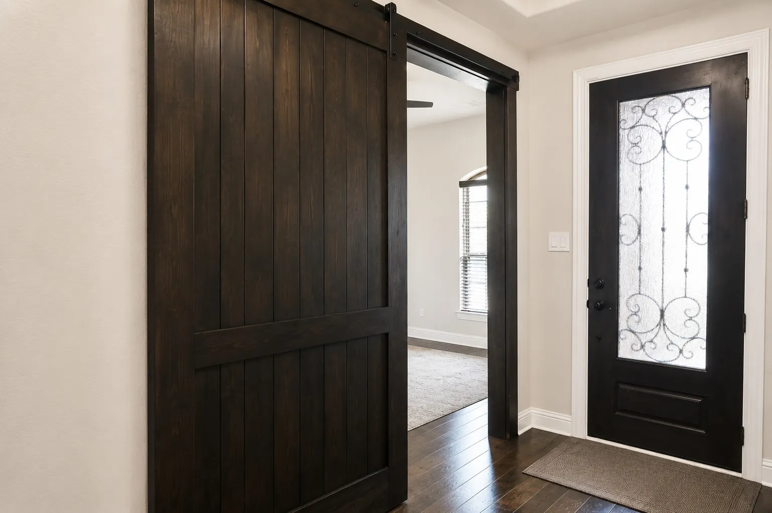 Barn door entry featuring dark wood-finish paneling and black hardware