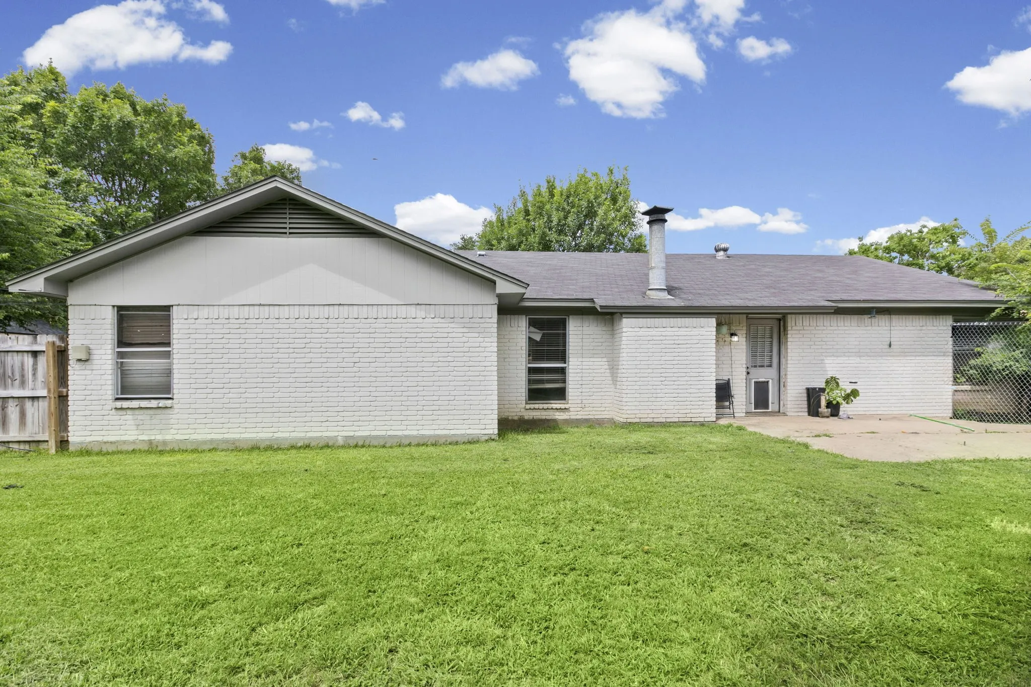 Spacious grassy yard with an expansive concrete patio