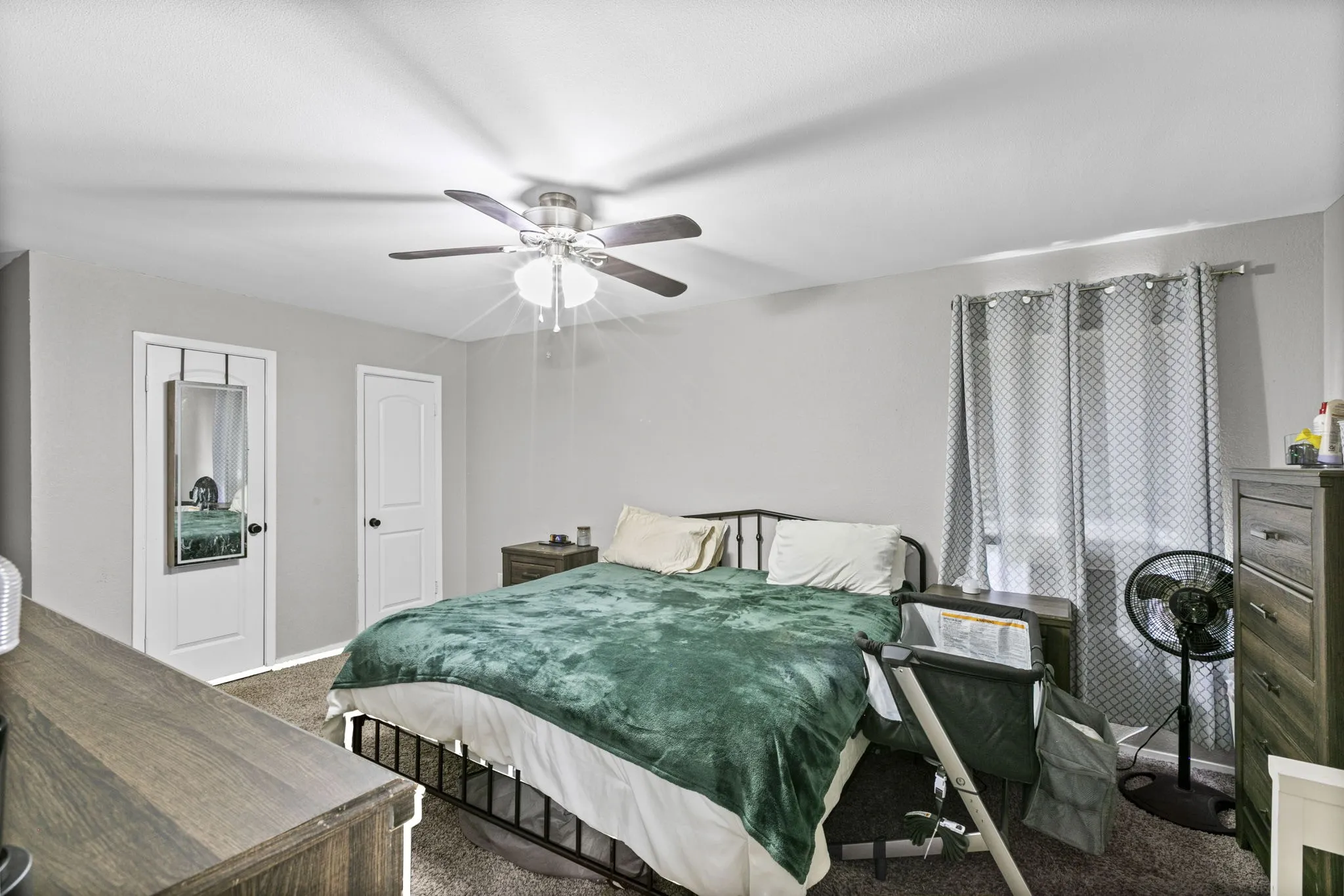 Neutral wall color, ceiling fan with light fixture, carpeted flooring, and white paneled doors