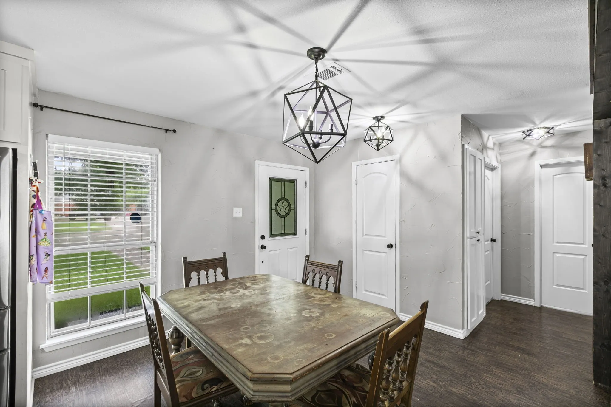 Dining area featuring wood-finish flooring and a window with blinds