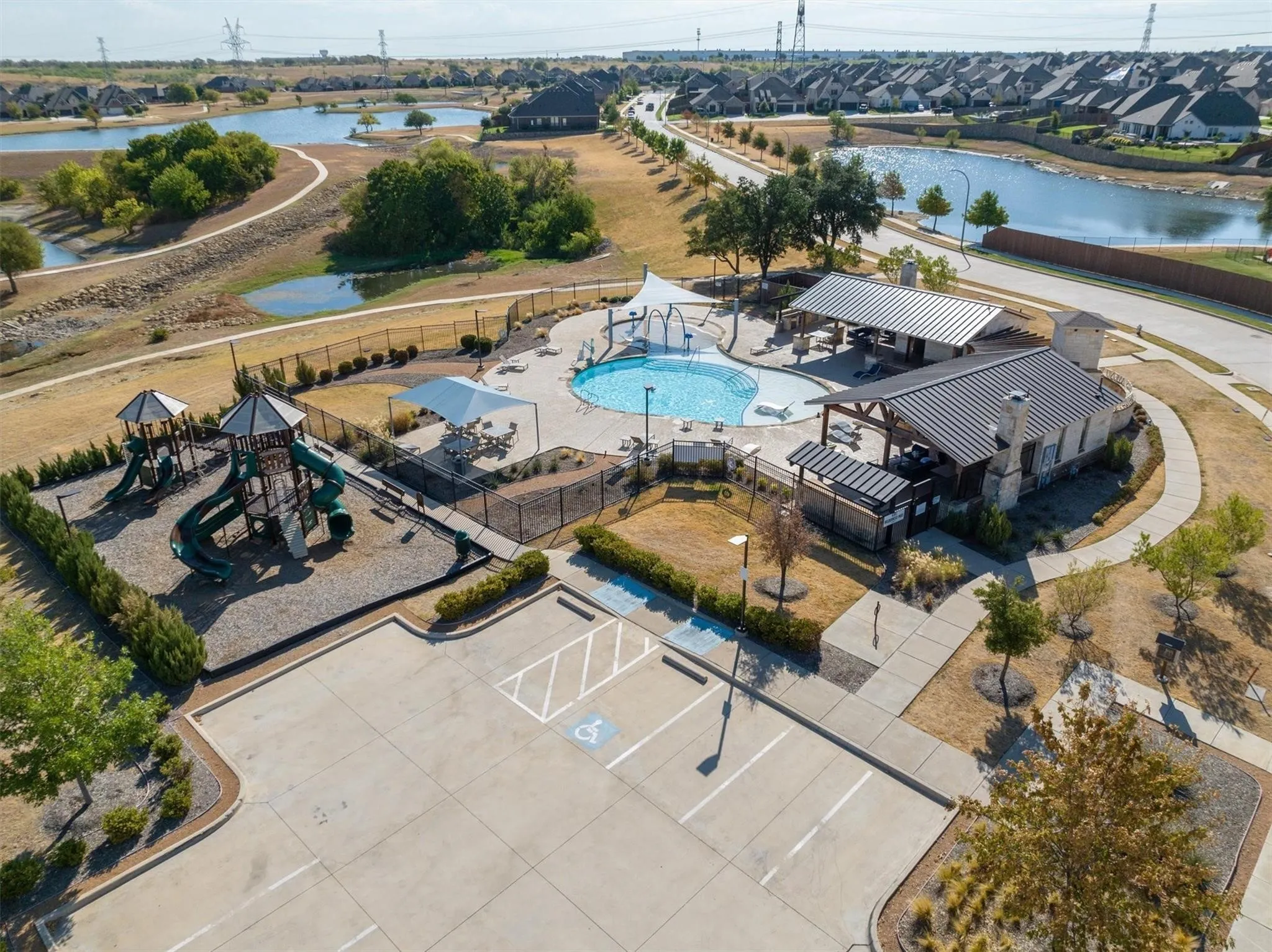 Community amenity center featuring a swimming pool, covered outdoor lounge areas, and a playground