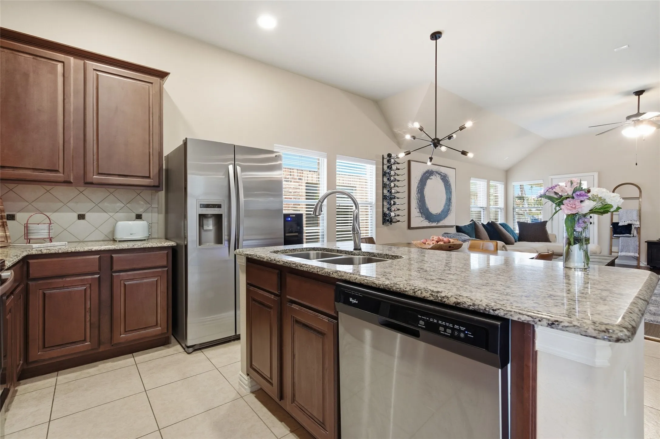 Kitchen island with granite countertop, double basin sink, and stainless steel dishwasher