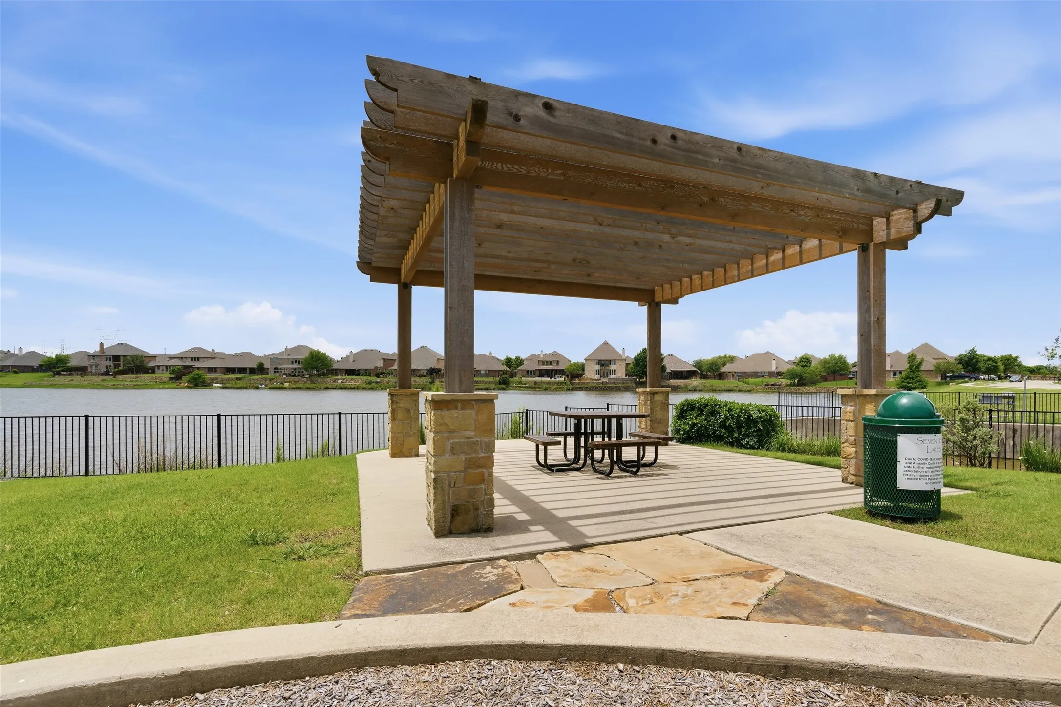 Open-air pergola next to lake with picnic table