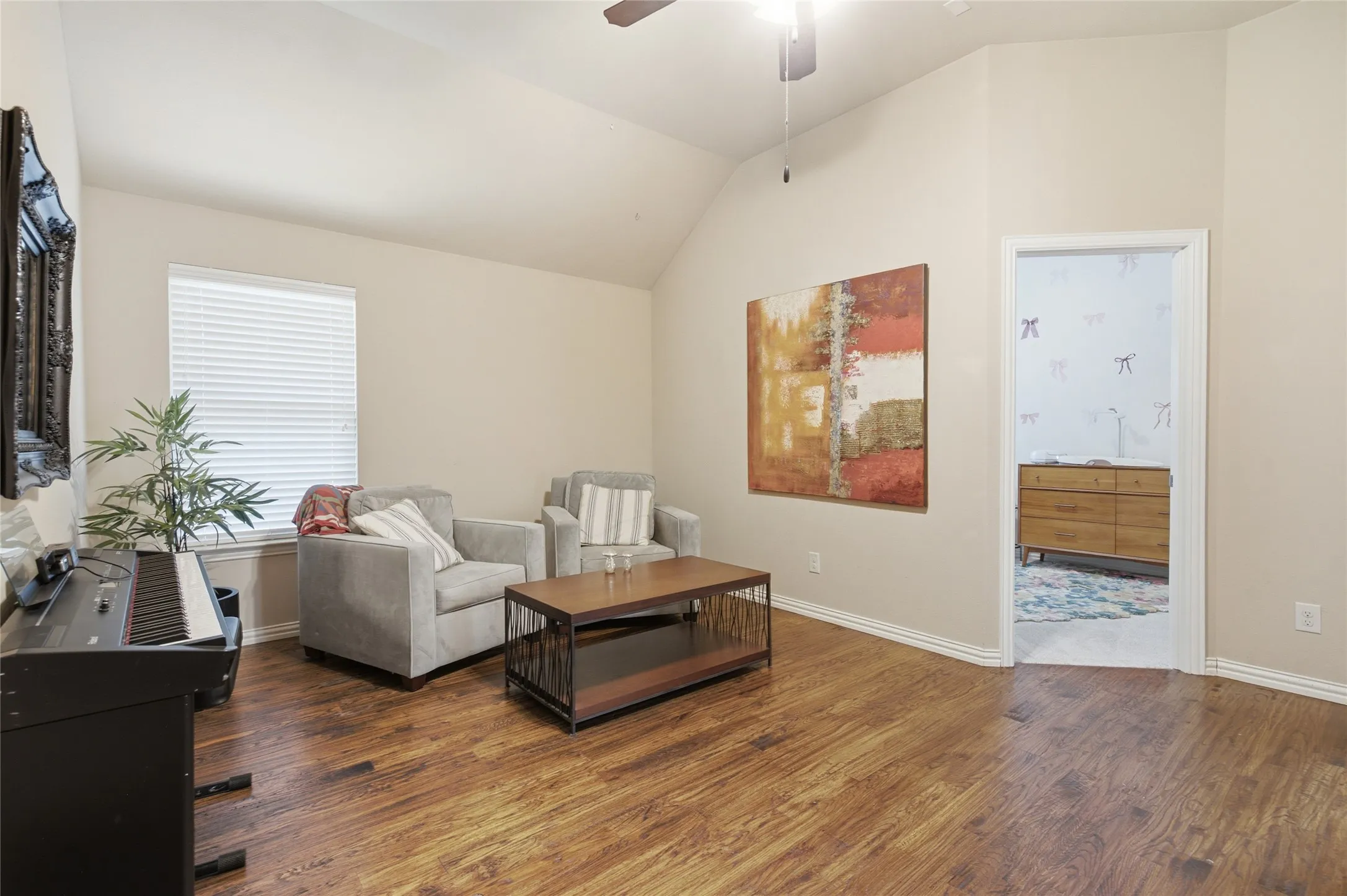 Spacious room featuring vaulted ceilings and hardwood floors
