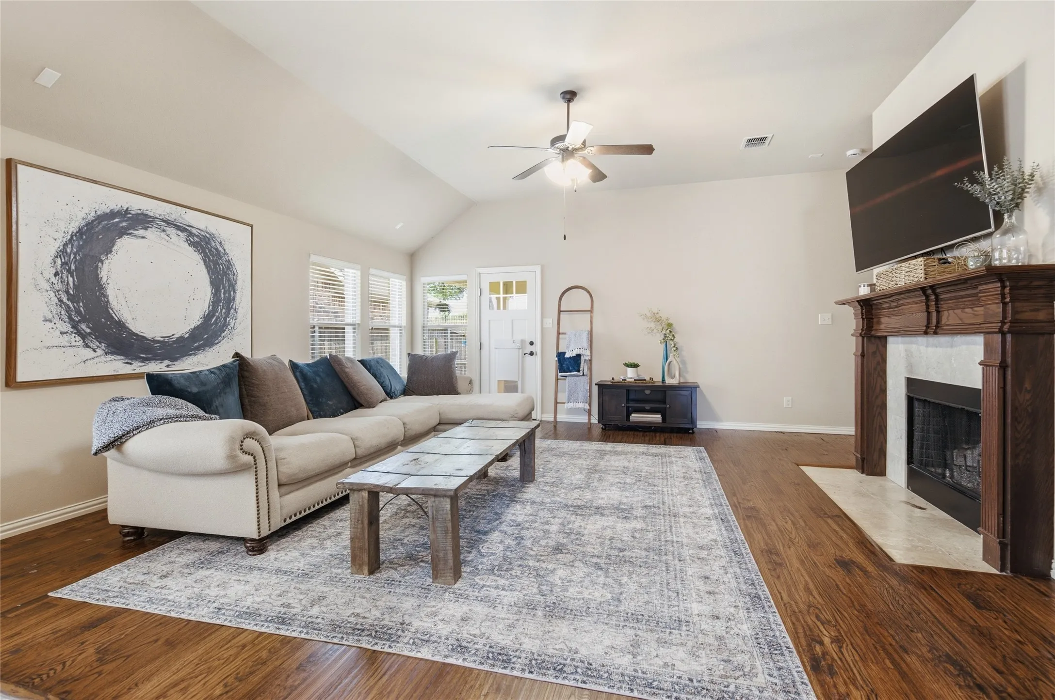 Spacious living area featuring vaulted ceilings and custom onsite finished wood floors.