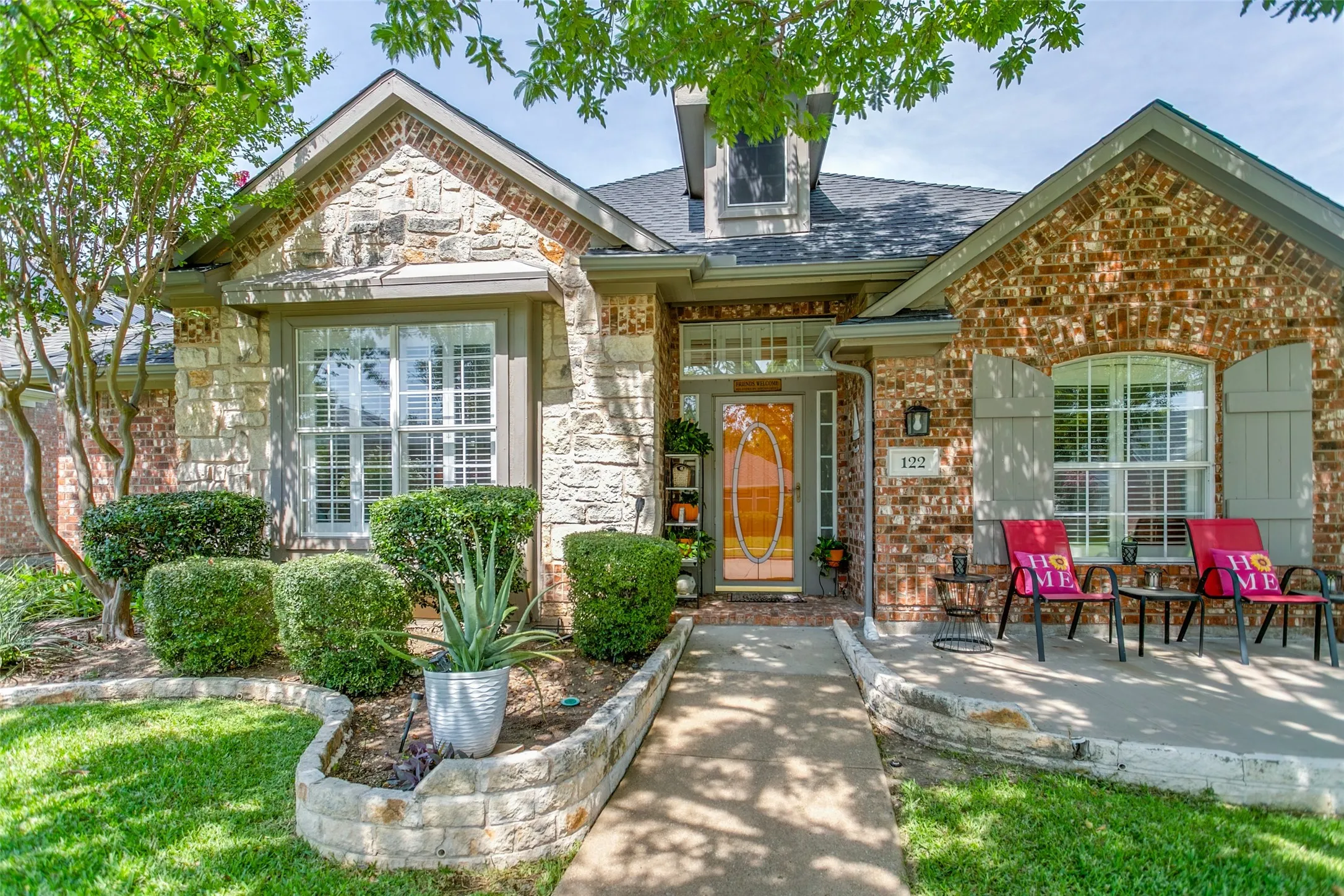 Stone and brick entry with extended patio and flower beds. Covered Porch and a great shade tree. Great curb appeal.
