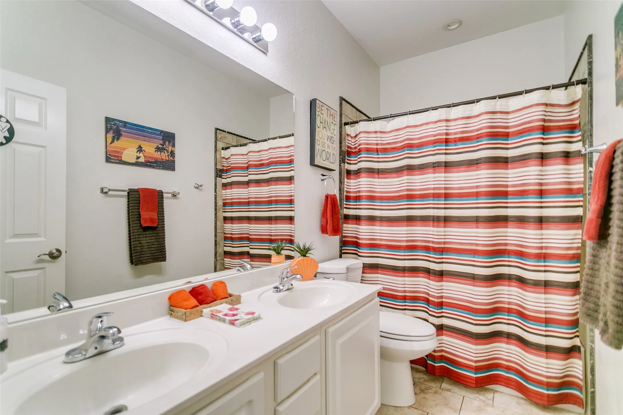 Secondary bathroom shared with the two bedrooms and guests.  Dual sinks and updated lighting.