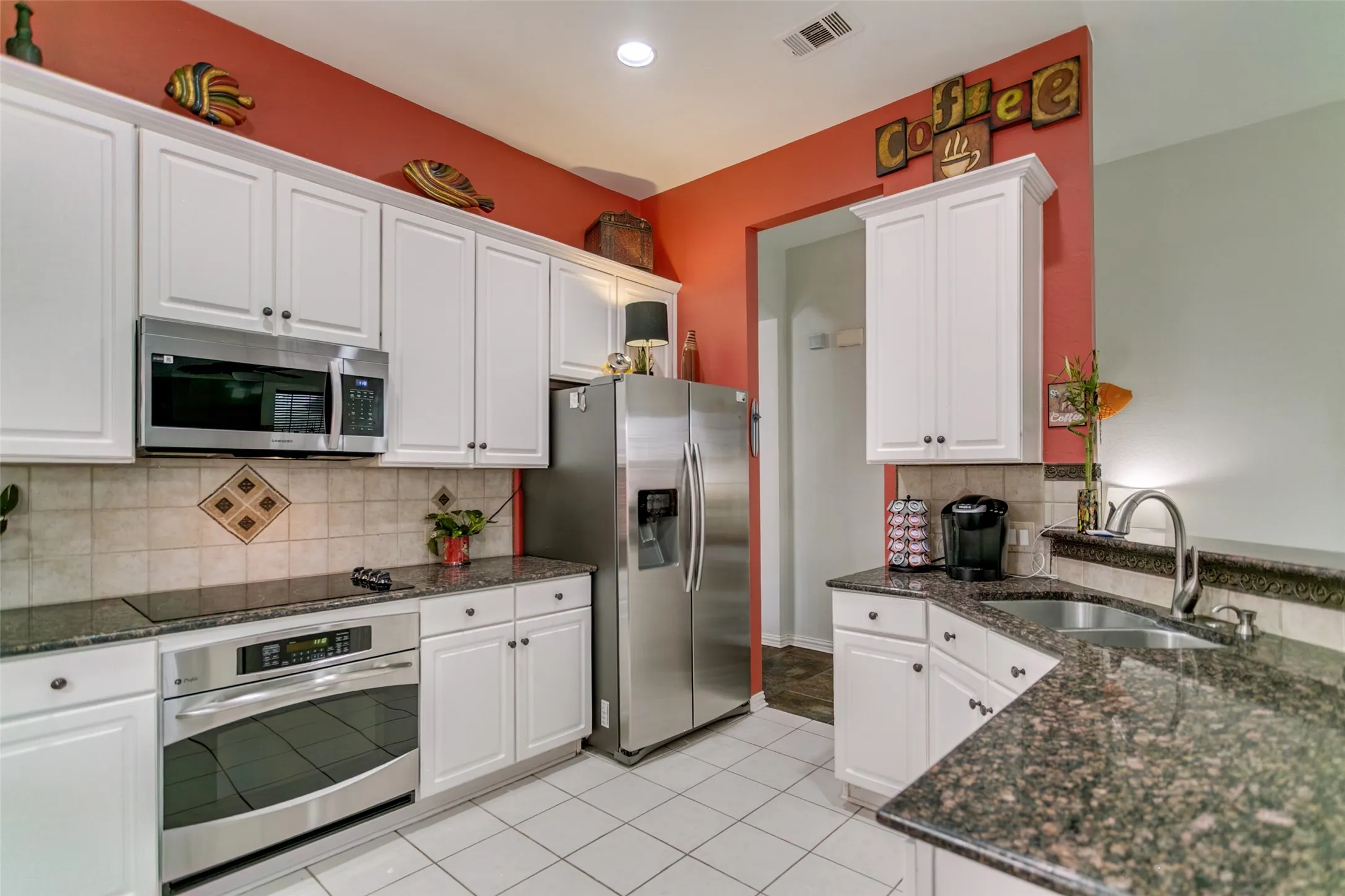 Open kitchen with granite and white cabinets.  SS appliances.