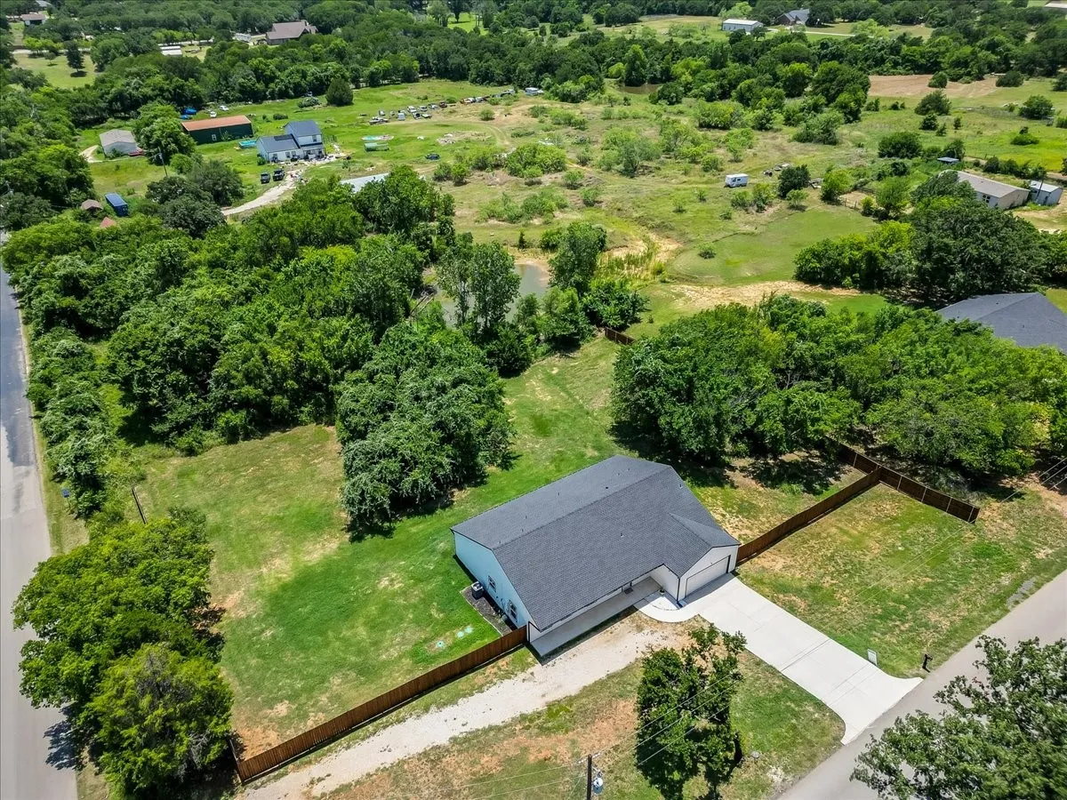 Single-story residence featuring a dark shingle roof and a concrete driveway