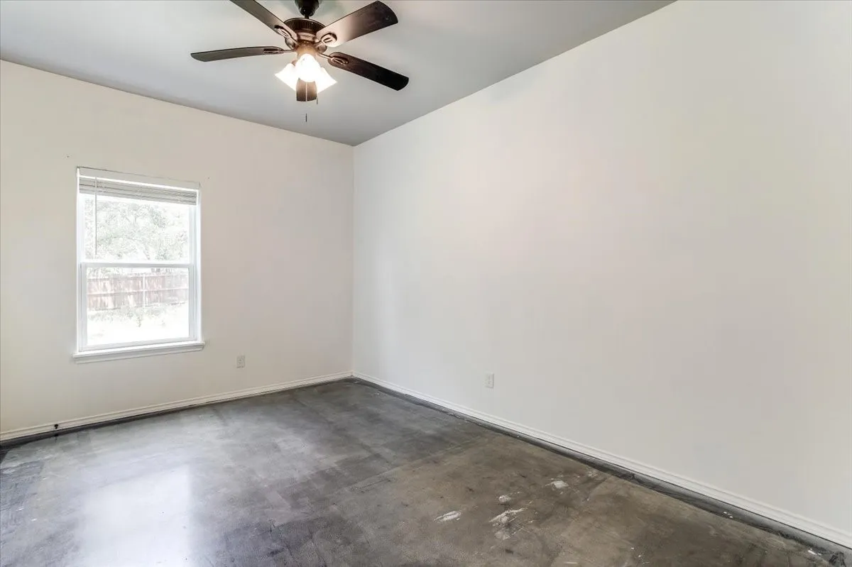 Room featuring a ceiling fan with integrated lighting, a double-hung window, and neutral wall tones