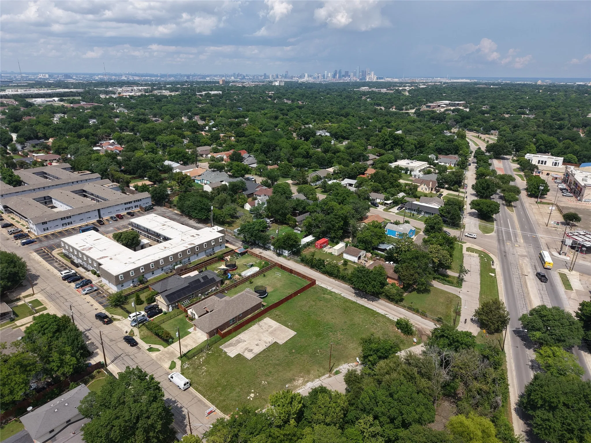 Expansive parcel featuring a large grassy area, a perimeter fence, and direct street frontage