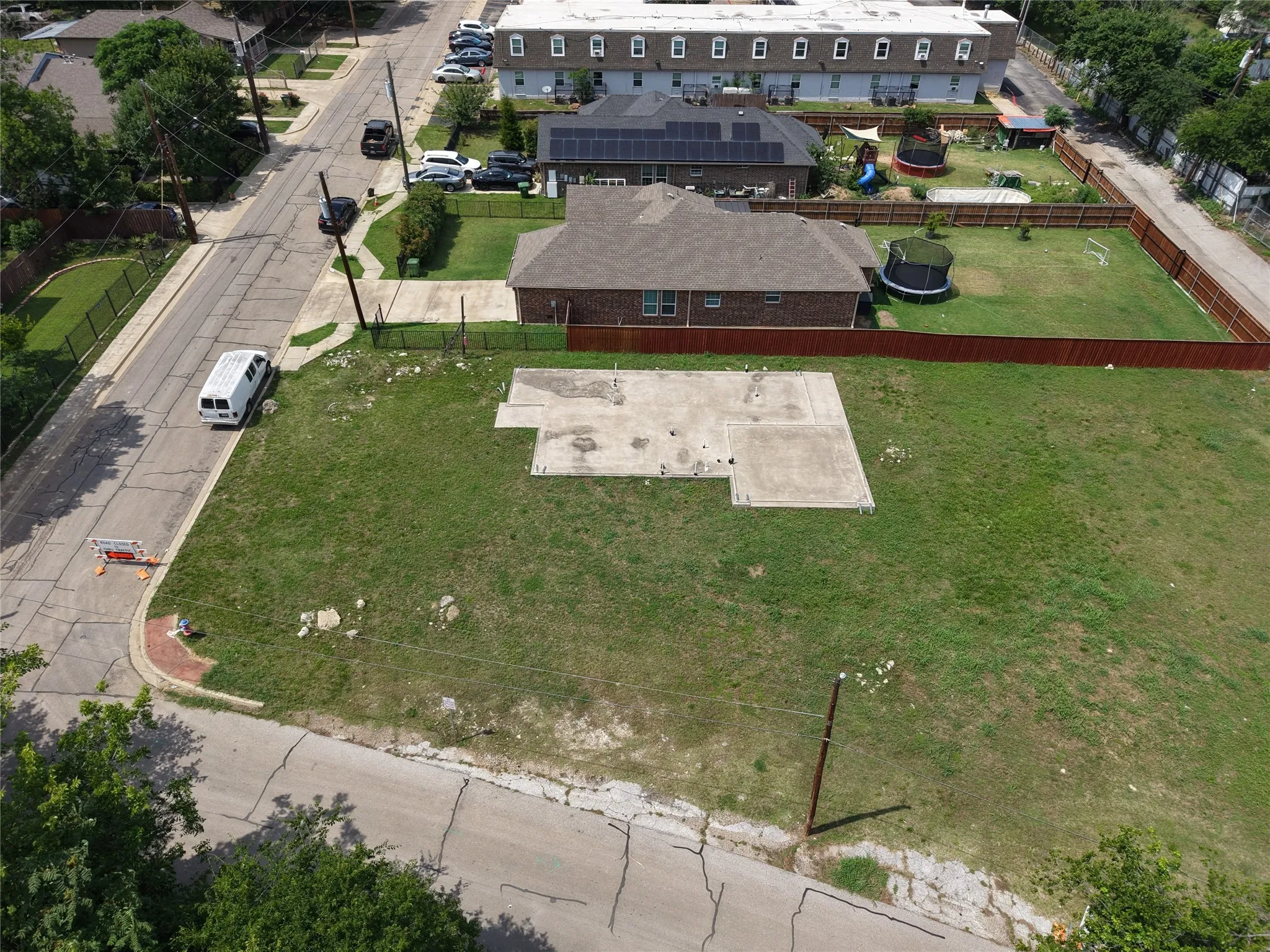 Expansive corner lot featuring a partial concrete slab and surrounding grassy areas