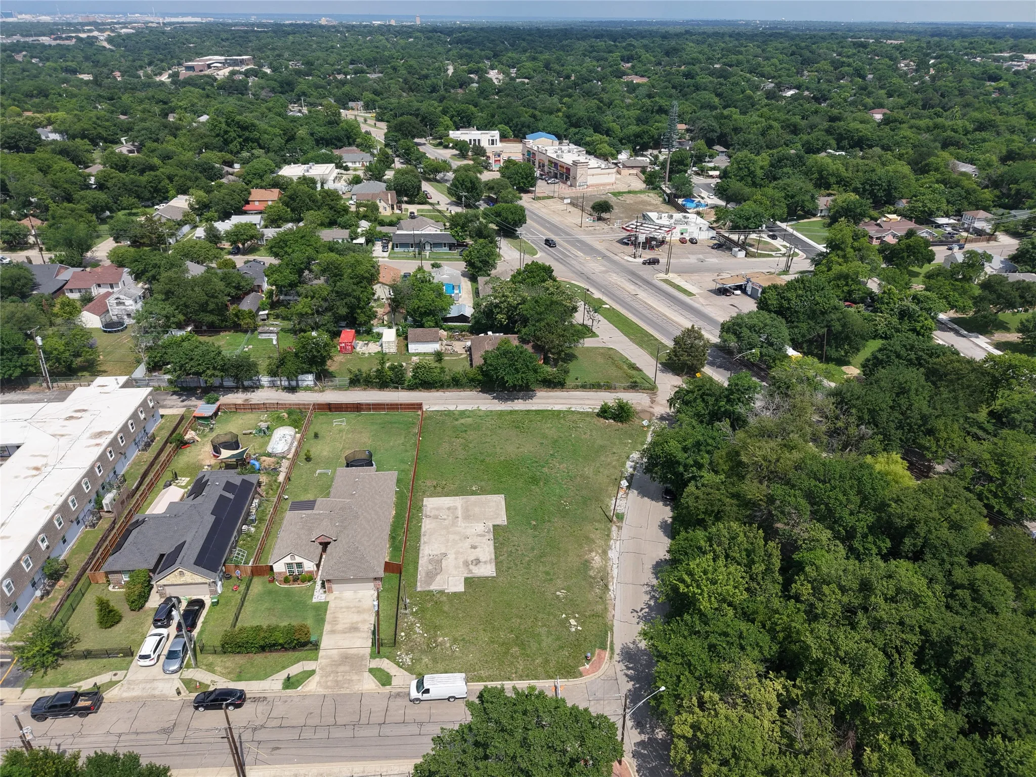 Expansive aerial perspective showcasing a residential structure with a light-colored roof and a concrete driveway