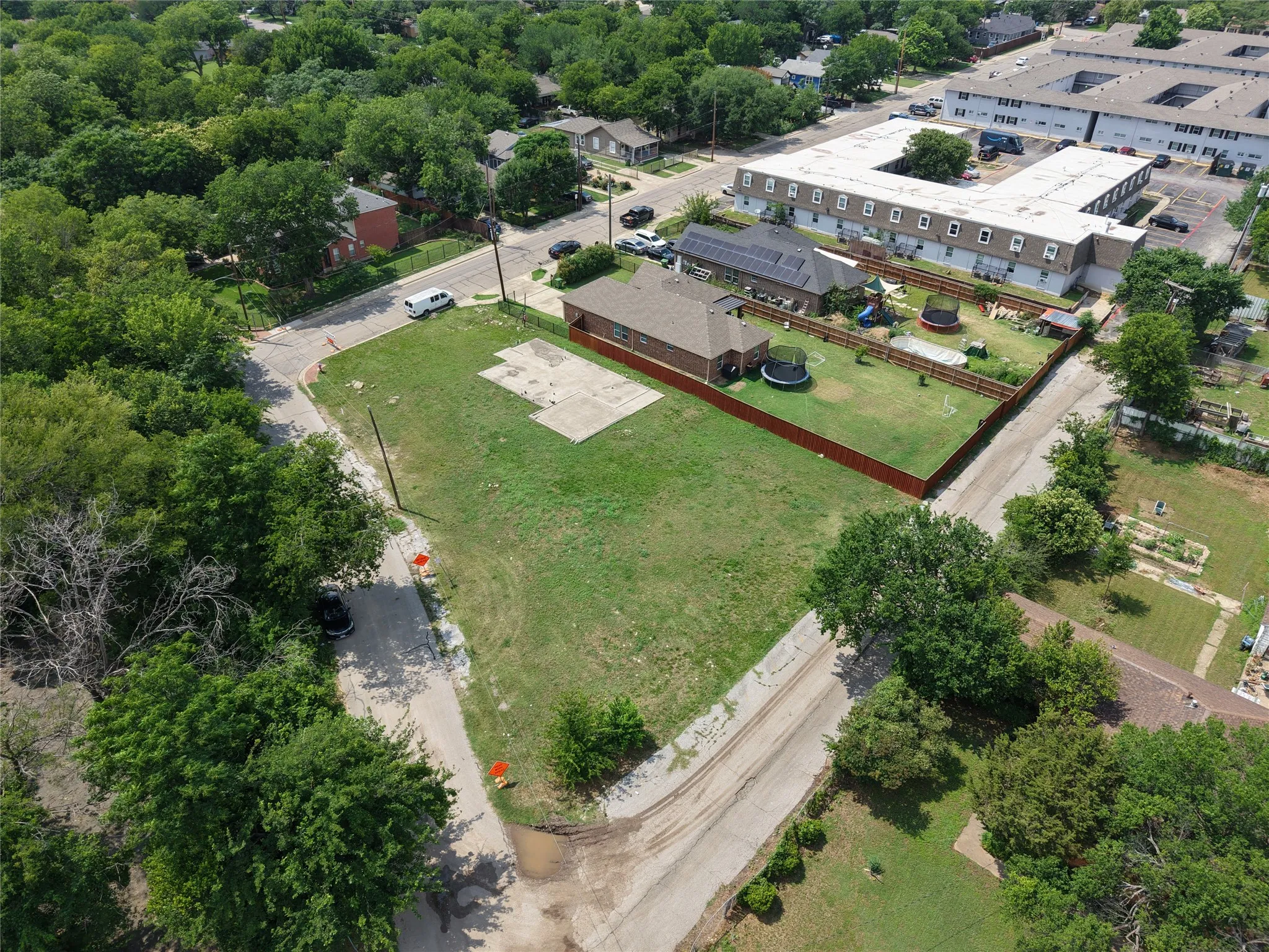 Expansive corner lot with existing foundation pad, surrounded by mature trees