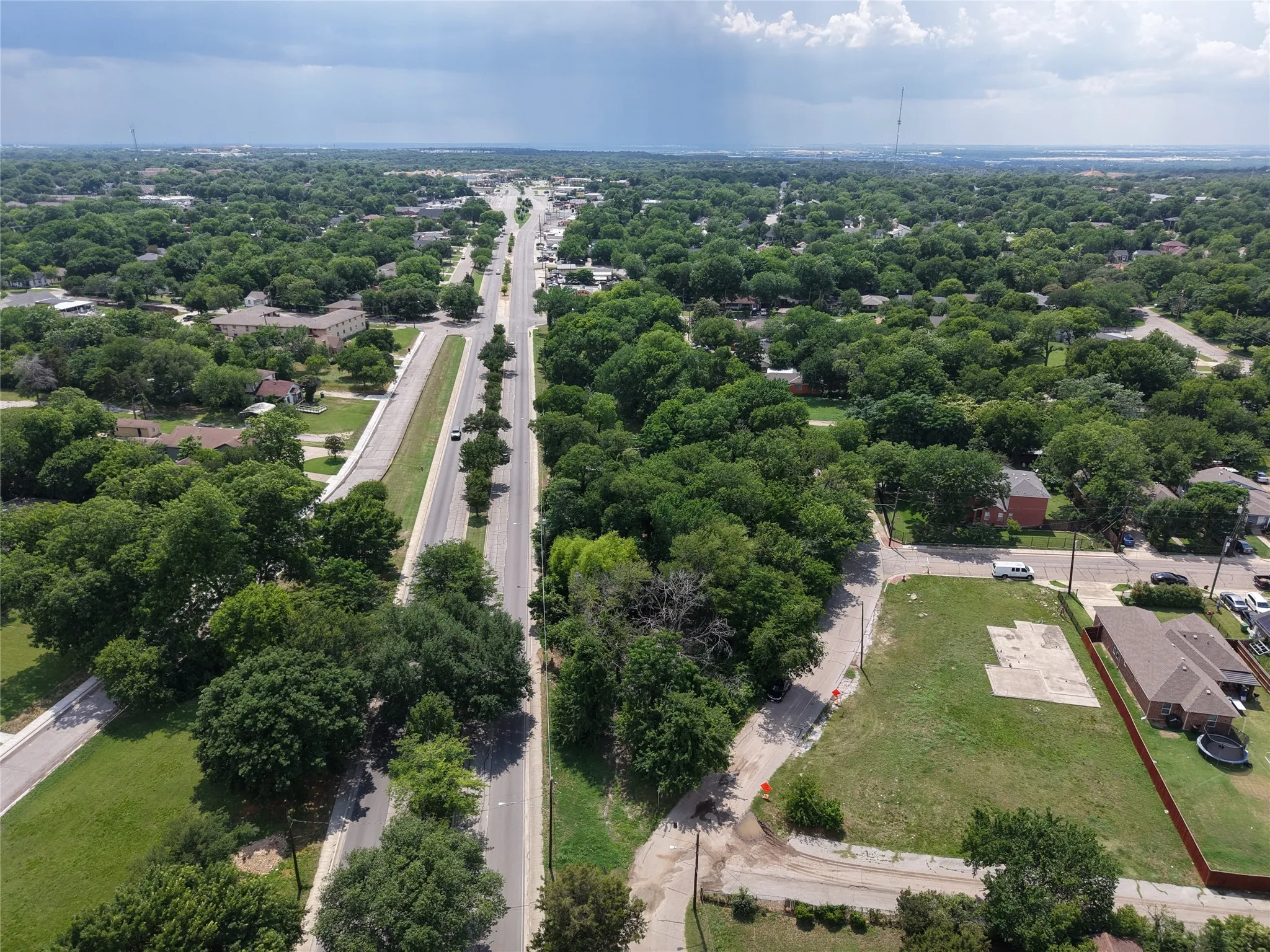 Aerial perspective of a verdant residential area featuring extensive tree coverage and established roads
