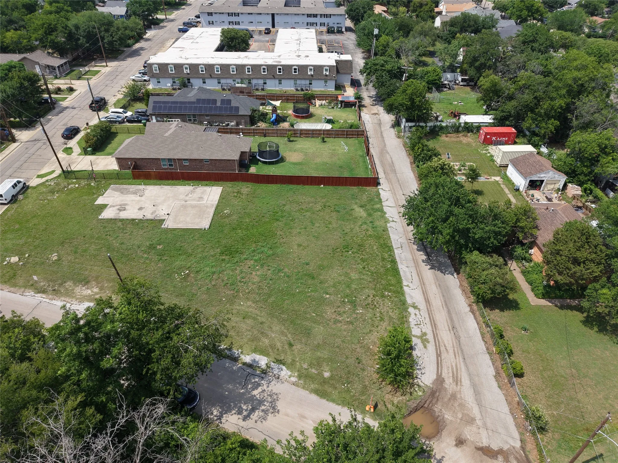 Expansive grass lot featuring a partial concrete slab