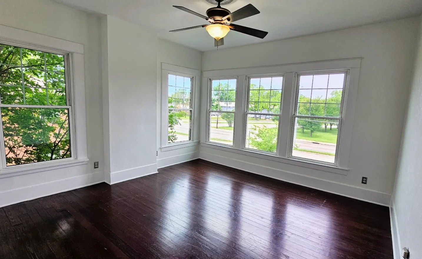 Room featuring dark wood-finish flooring, white trim, and white walls