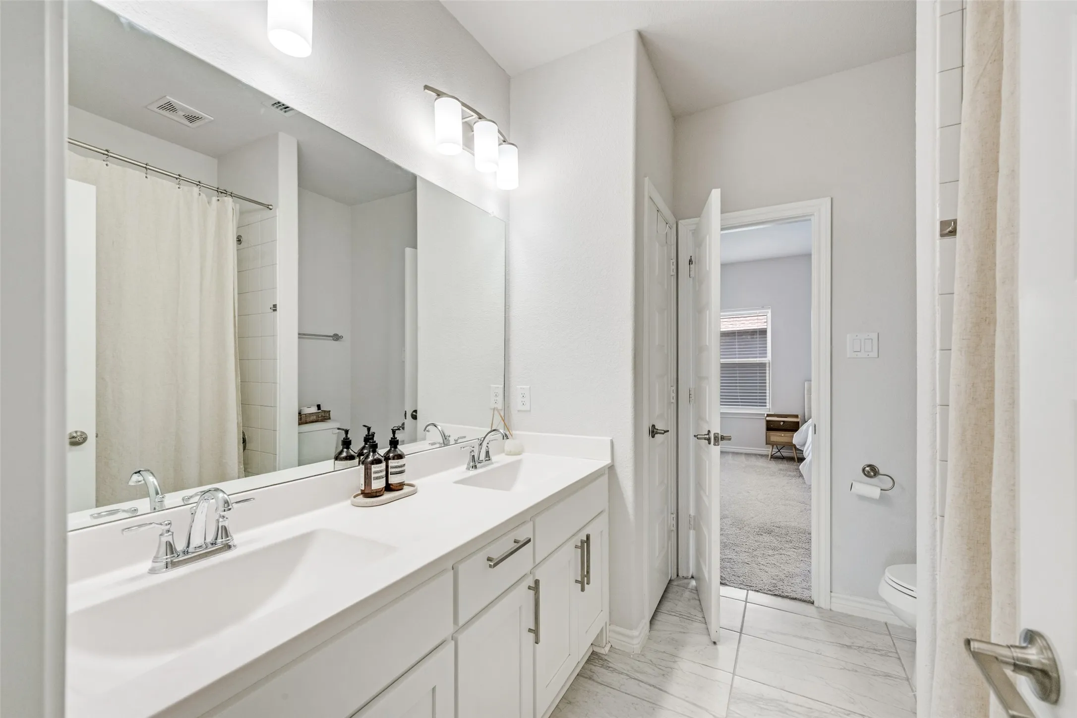 Jack and Jill Upstairs Bathroom featuring a dual vanity with white cabinetry and chrome fixtures