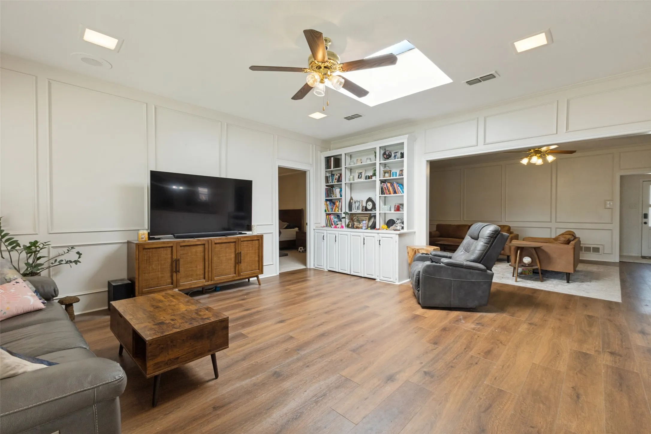 Spacious living area featuring wood-finish flooring, recessed lighting, and a ceiling fan