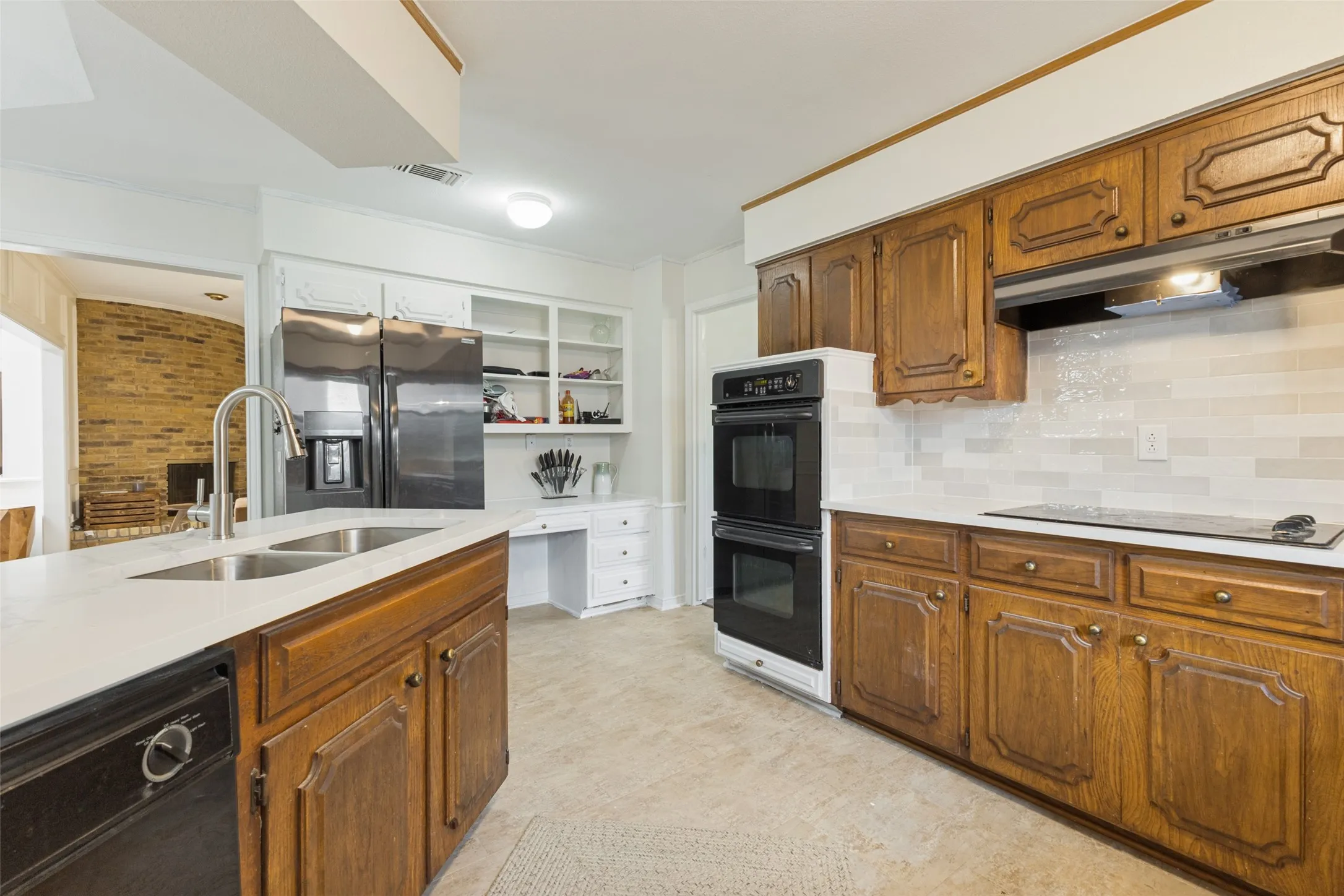Kitchen featuring wood cabinetry, light-toned countertops, and a subway tile backsplash