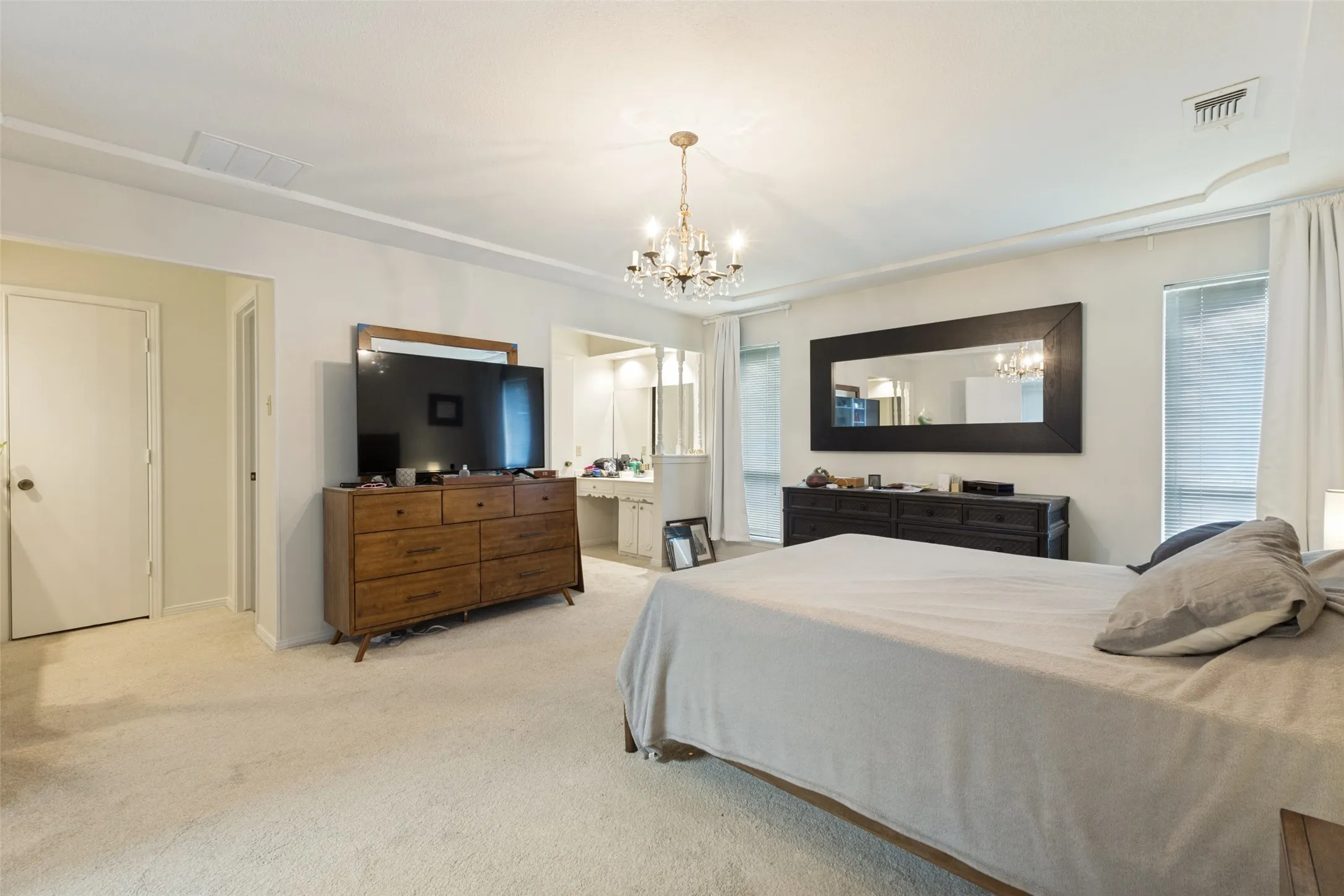 Spacious bedroom featuring light-toned carpet flooring and neutral wall tones