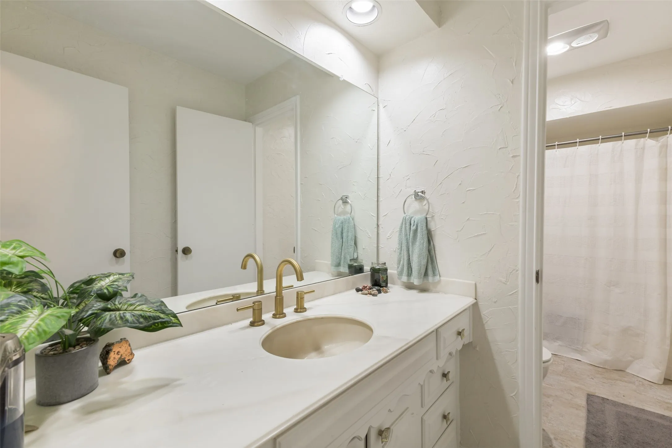 Bathroom vanity with a brass-finish faucet, an undermount sink, and a framed mirror