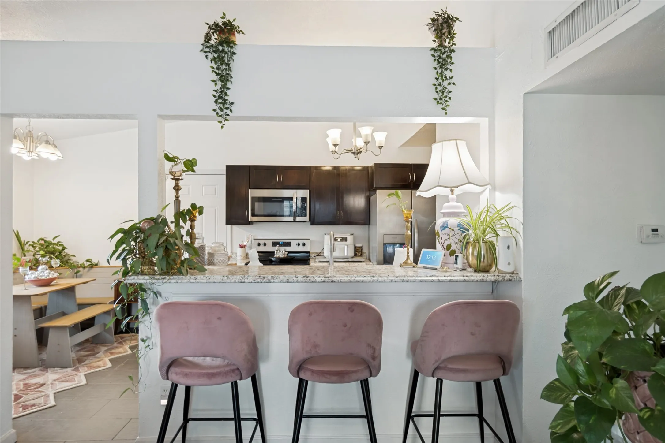 Kitchen featuring a pass-through bar with a light granite countertop