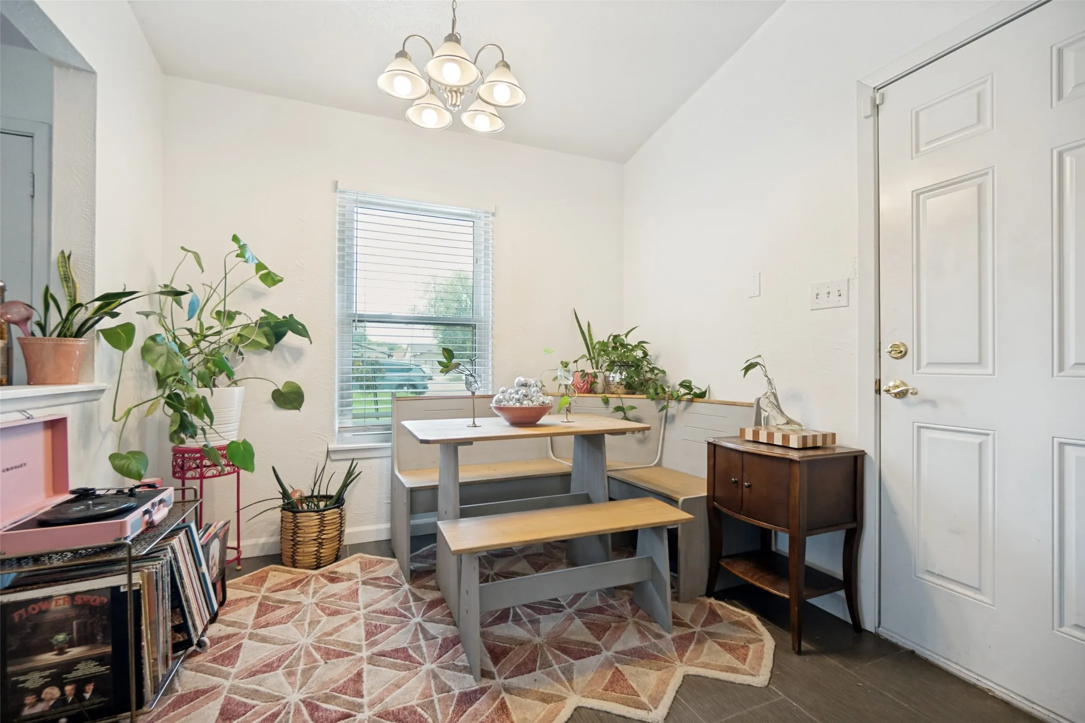 Dining area with dark wood-finish flooring and a multi-light ceiling fixture