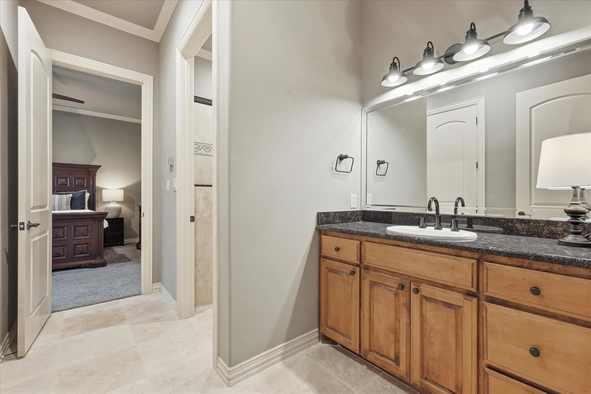 1st floor Jack and Jill bathroom with knotty alder cabinetry, granite, double crown molding, separate zoned thermostat, bathtub with shower, large linen closet and new Turkish travertine flooring.