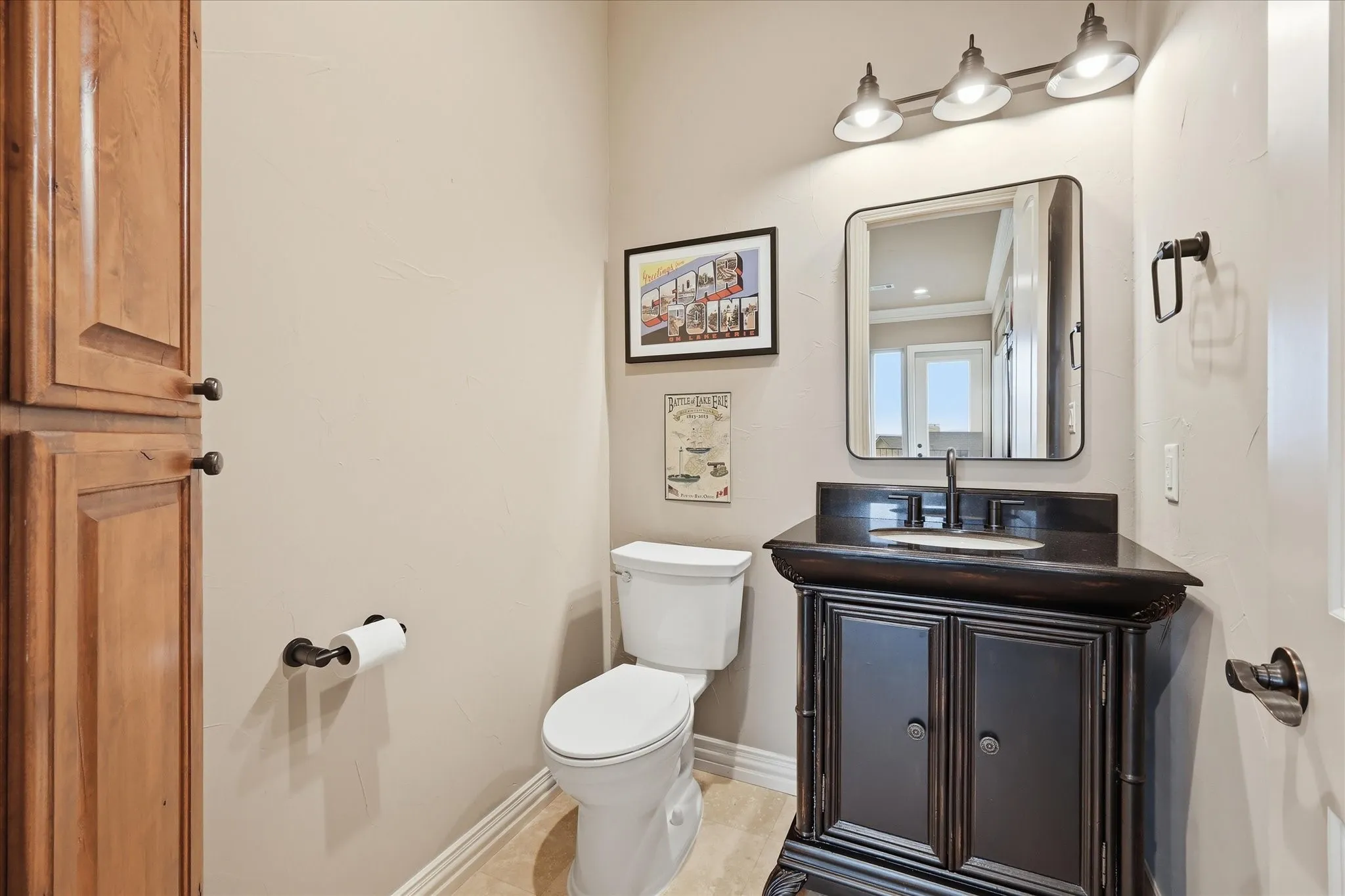 Game room half bath features a corner built in cabinet, Turkish travertine flooring, granite, new lighting, fixture and mirror.