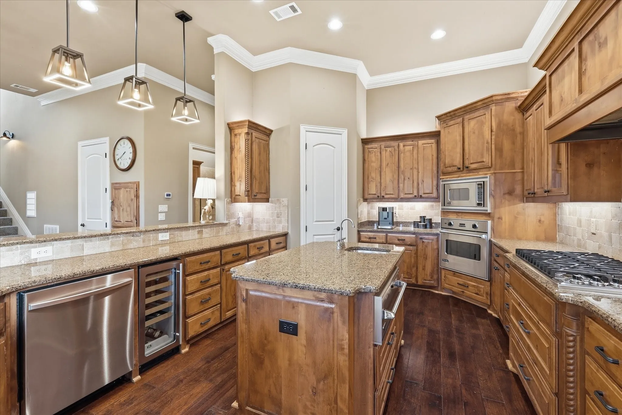 There's gleaming granite, a huge walk in pantry, a Uline wine refrigerator, knotty alder custom wood cabinets, a coffee bar, built in refrigerator, large island with additional sink, tons of task lighting, storage and prep space!
