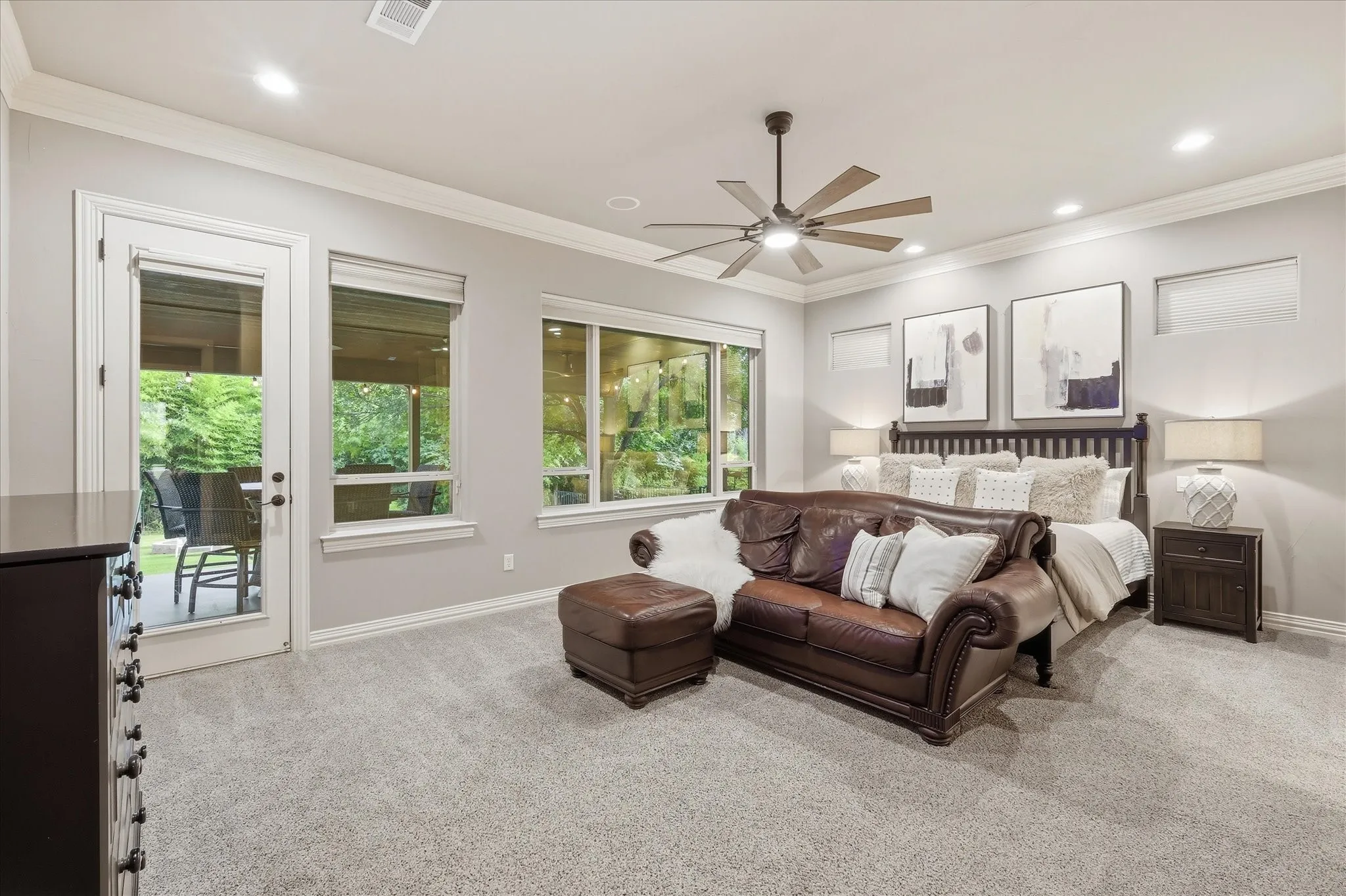 The primary suite features private access to the back 1st floor patio, remote controlled electric shades, new ceiling fan, upgraded can lighting, double crown molding, separate zoned thermostat and built in sound speakers.