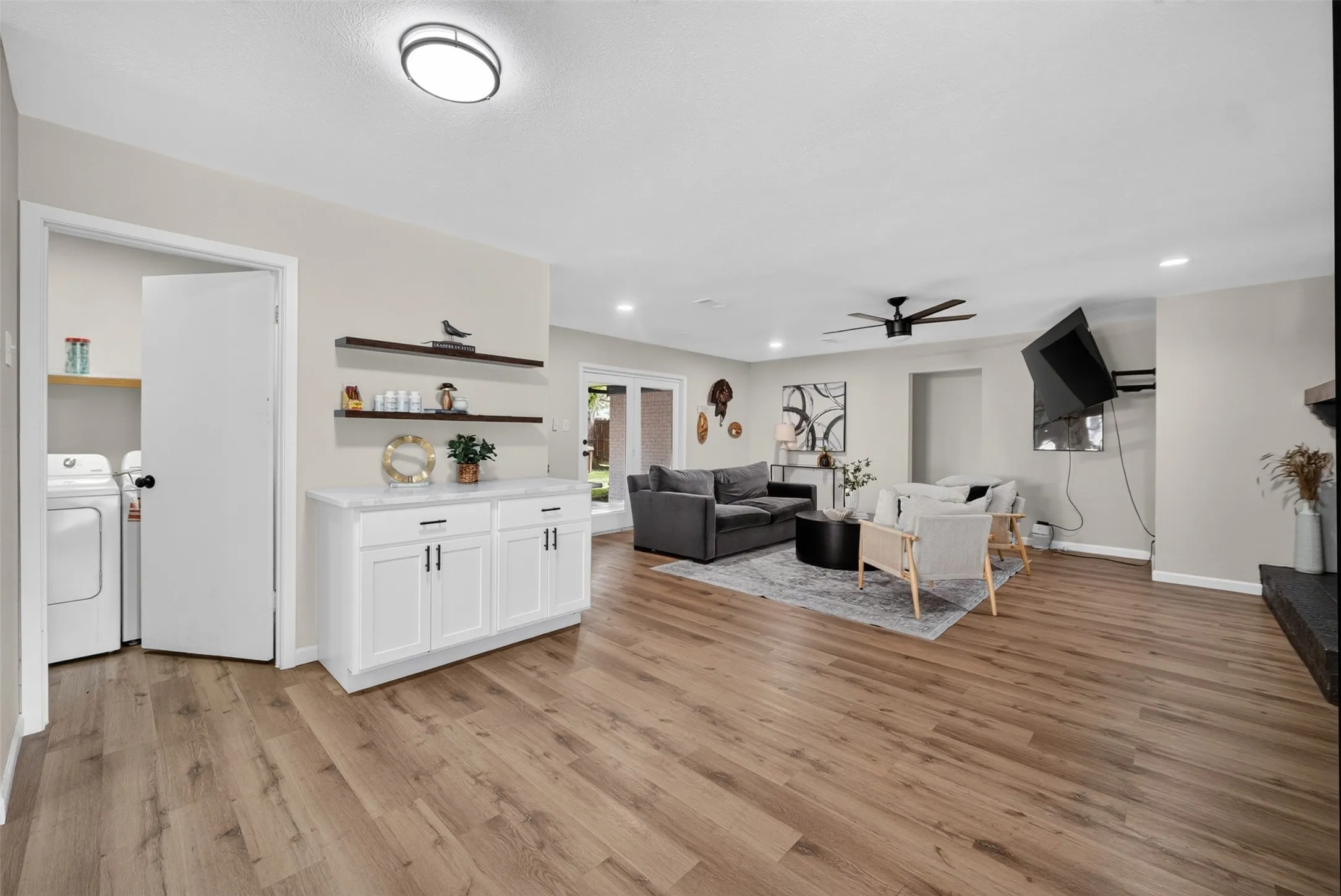 Spacious living area featuring wood-finish flooring, recessed lighting, and a ceiling fan