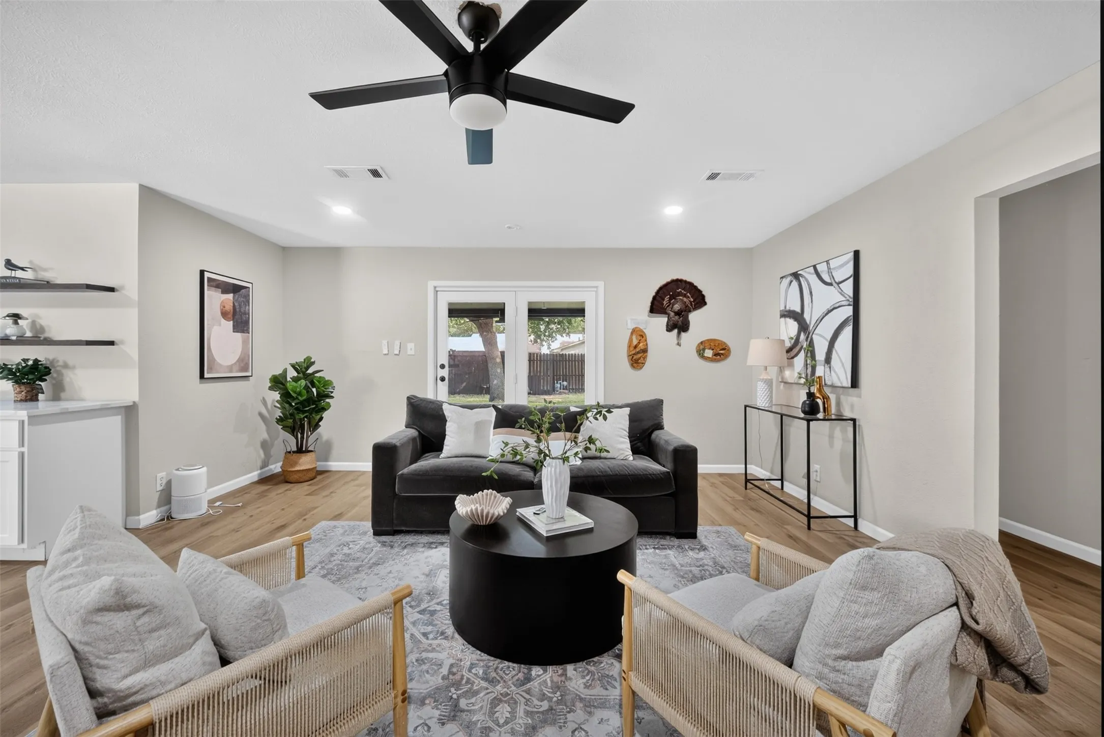 Spacious living area featuring wood-finish flooring, recessed lighting, and a contemporary ceiling fan