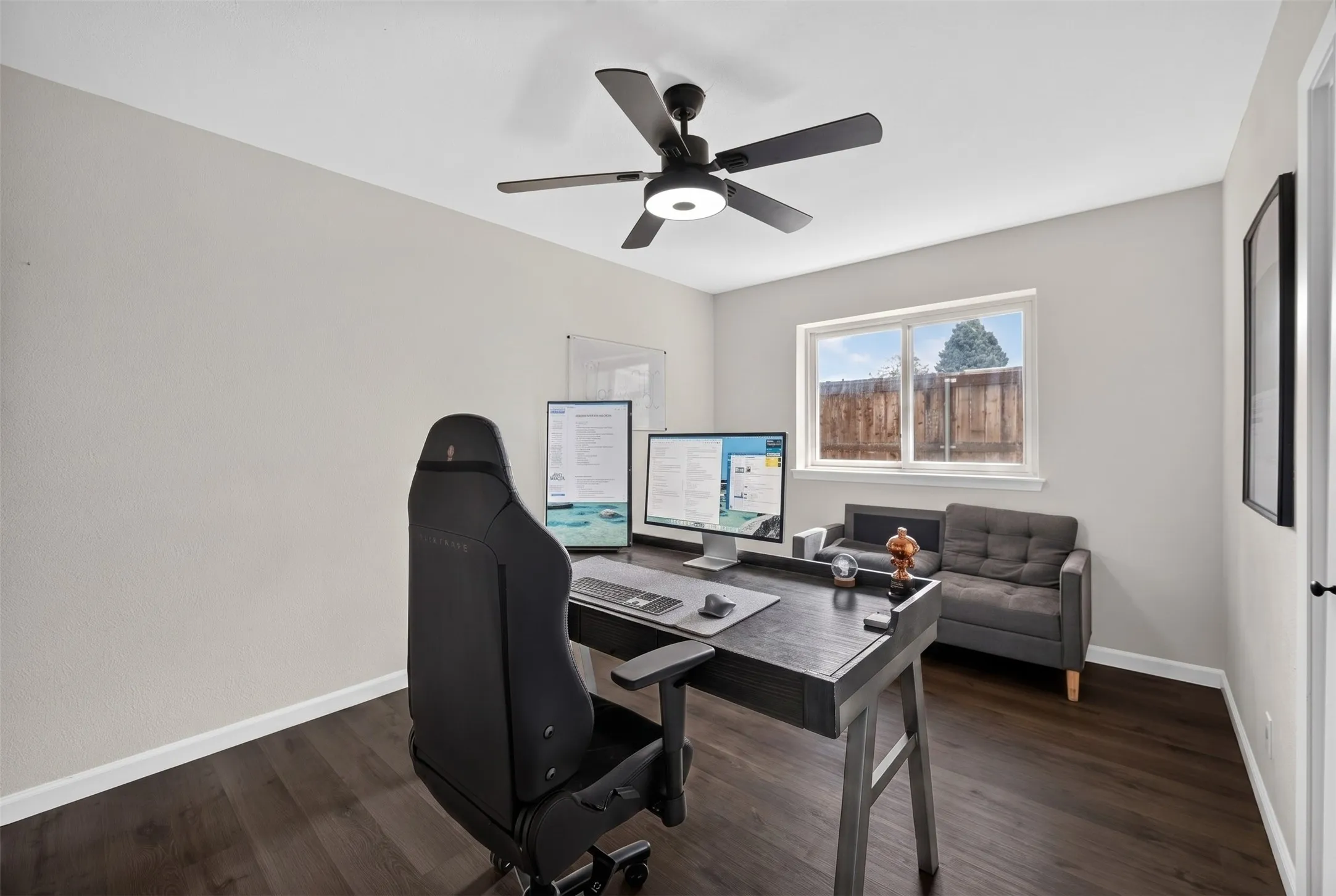 Room featuring dark wood-finish flooring, light neutral-toned walls, and a white window frame with a multi-pane window