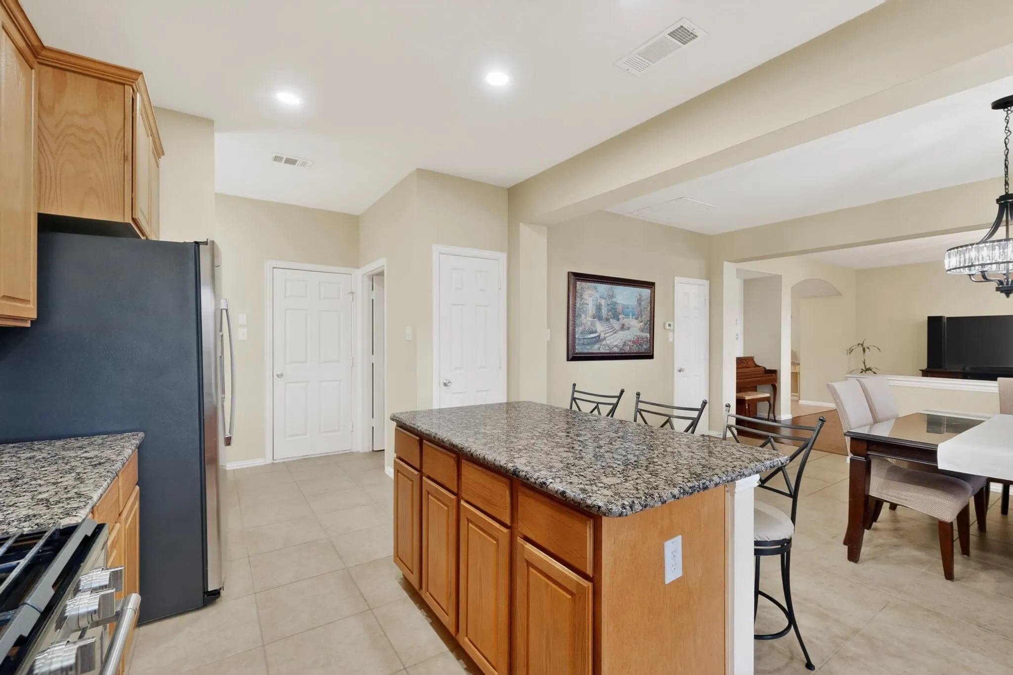 Kitchen featuring an island with granite countertop, wood cabinetry, and recessed lighting