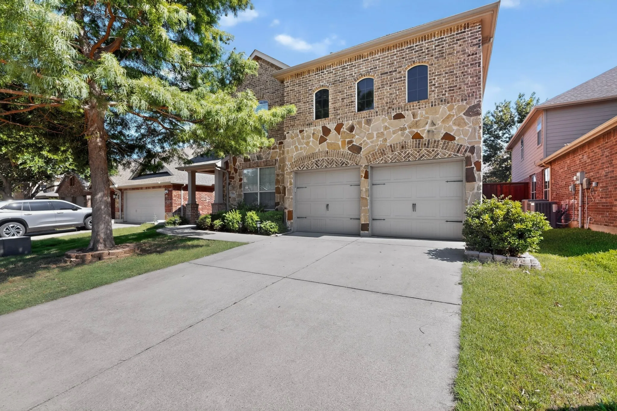Facade featuring a combination of brick and stone masonry with arched accents